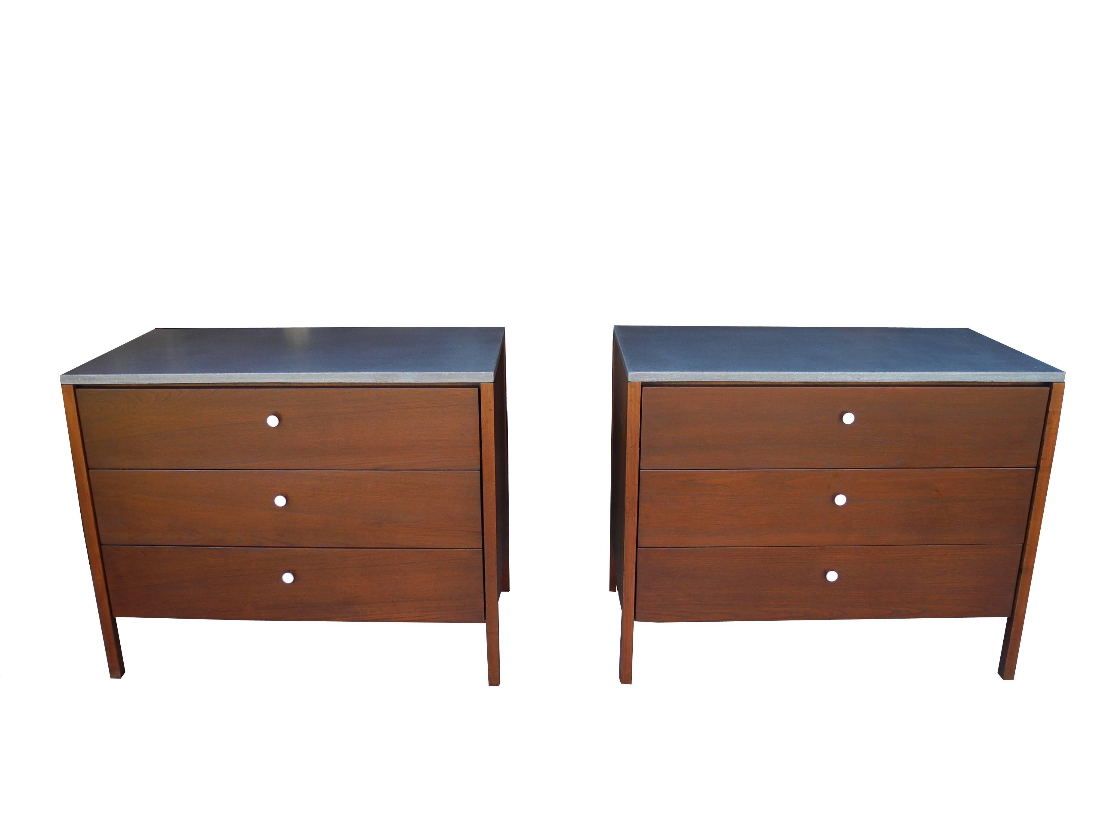 These dressers or nightstands are made of walnut with grey concrete tops and white metal pulls. The concrete is the color of slate (middle grey). A handsome combination.
