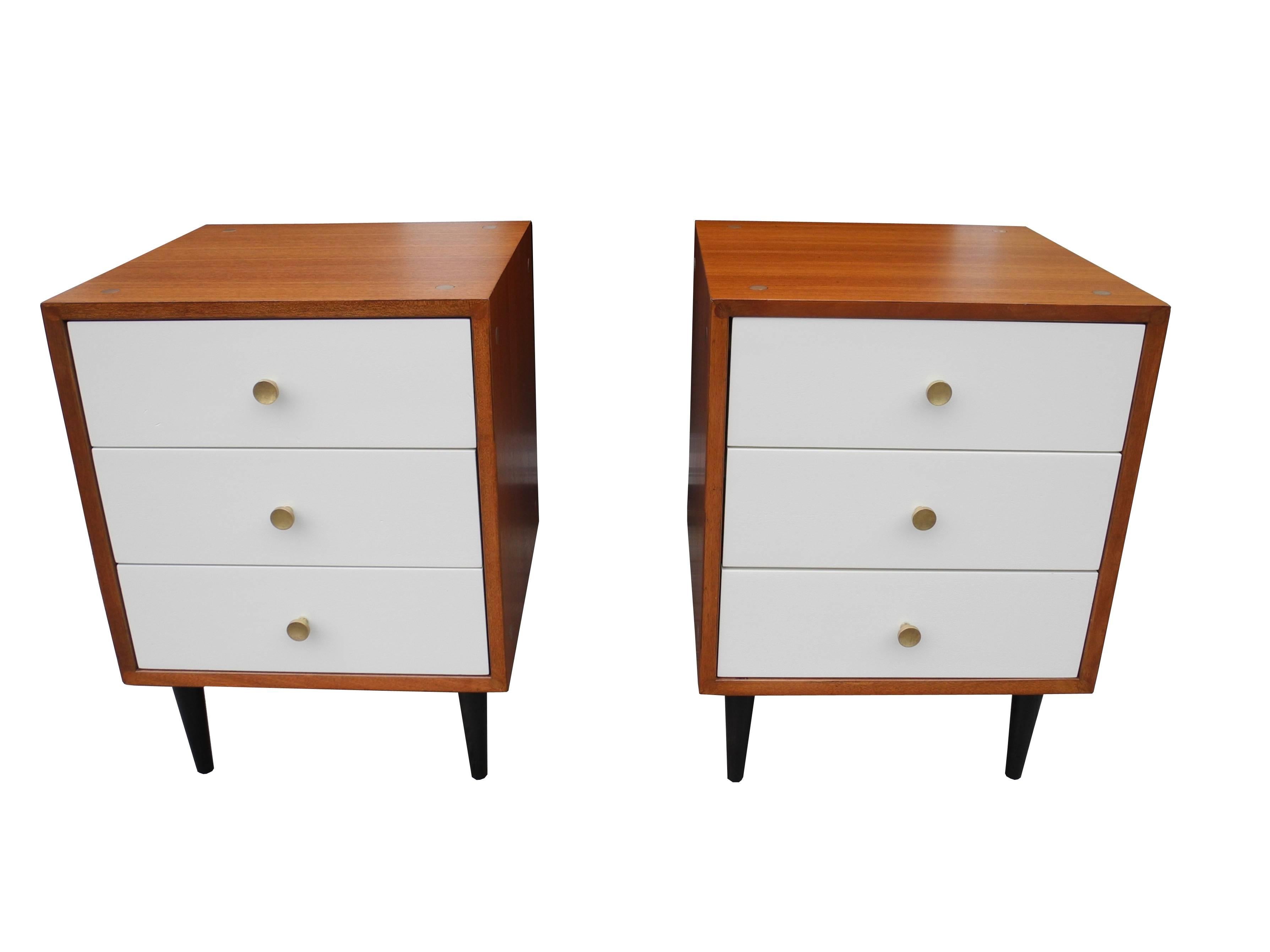 These bedside tables are made of mahogany. The drawer face is painted linen white. Drawer's insides are oak. Solid brass handles for pulls. This was part of an award winning design.