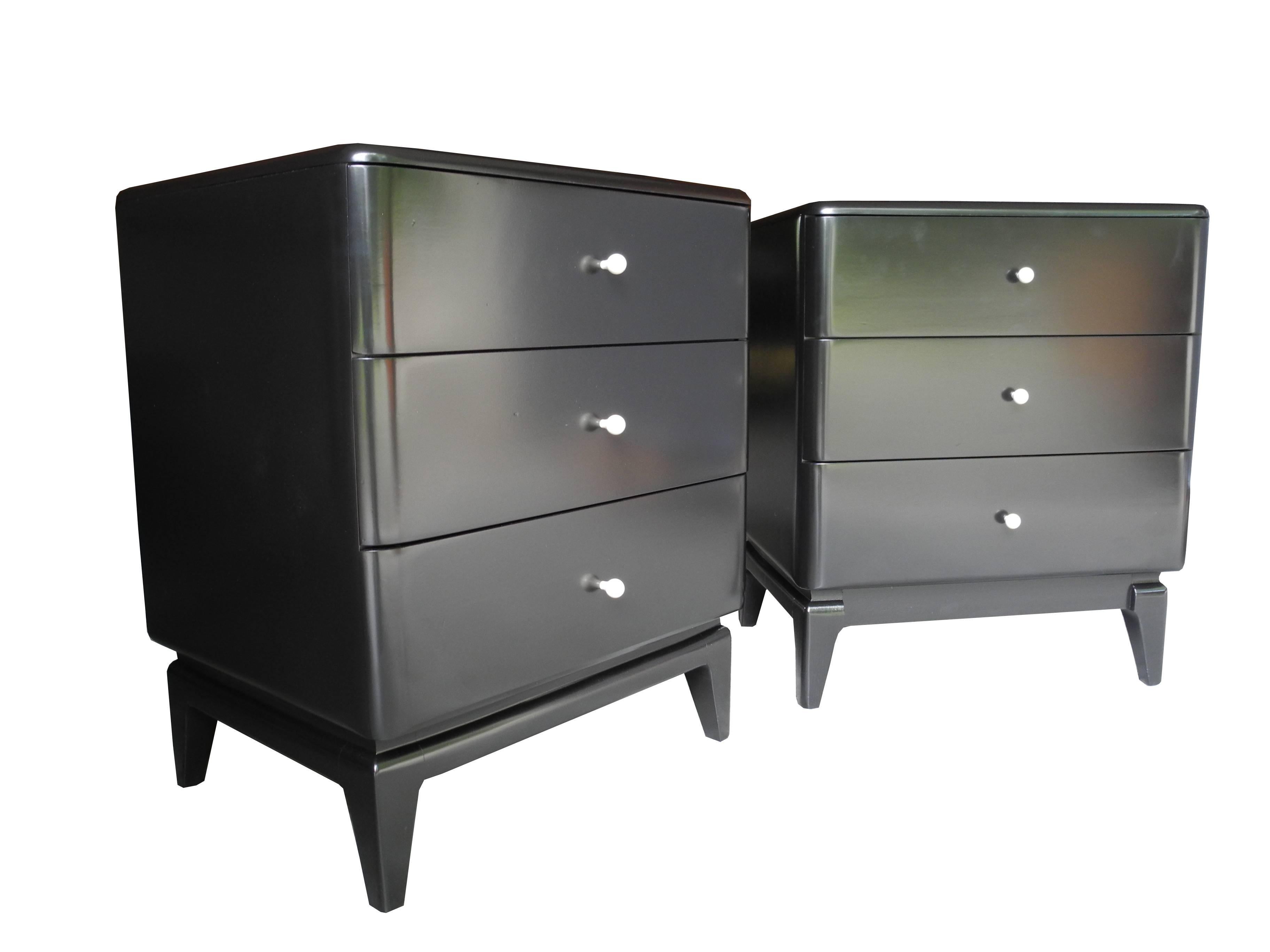 These vintage 1950s Heywood-Wakefield modern bedside dressers are made of solid maple painted black and lacquered. Each nightstand has three drawers for plenty of storage. They have unique white porcelain knobs.
    