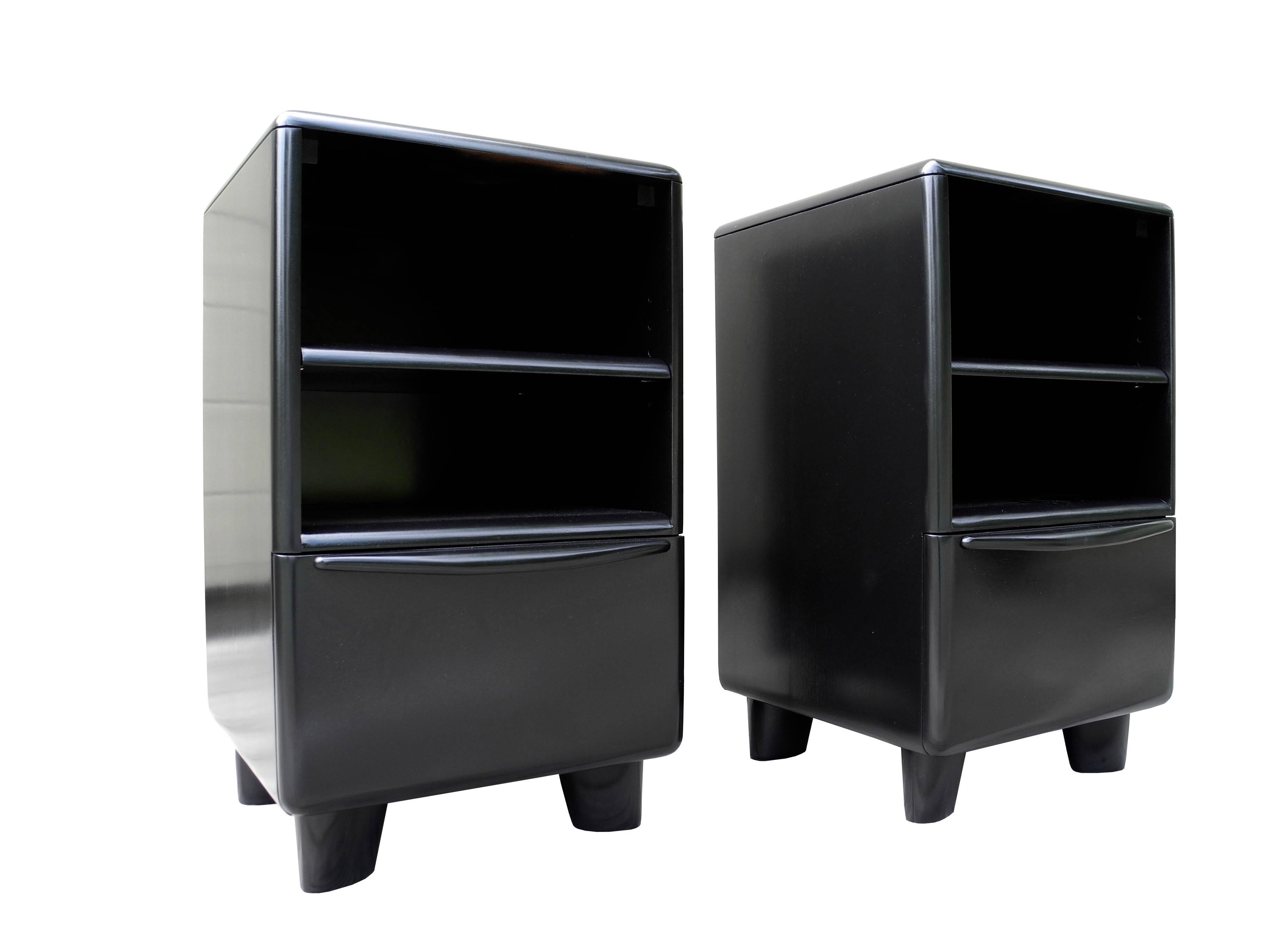 These Mid-Century Modern pair of solid maple bedside tables/nightstands are painted black and lacquered. They have a bottom drawer and adjustable shelf. Their simple design and organic rounded edges depicts the modern style of the 1950s.