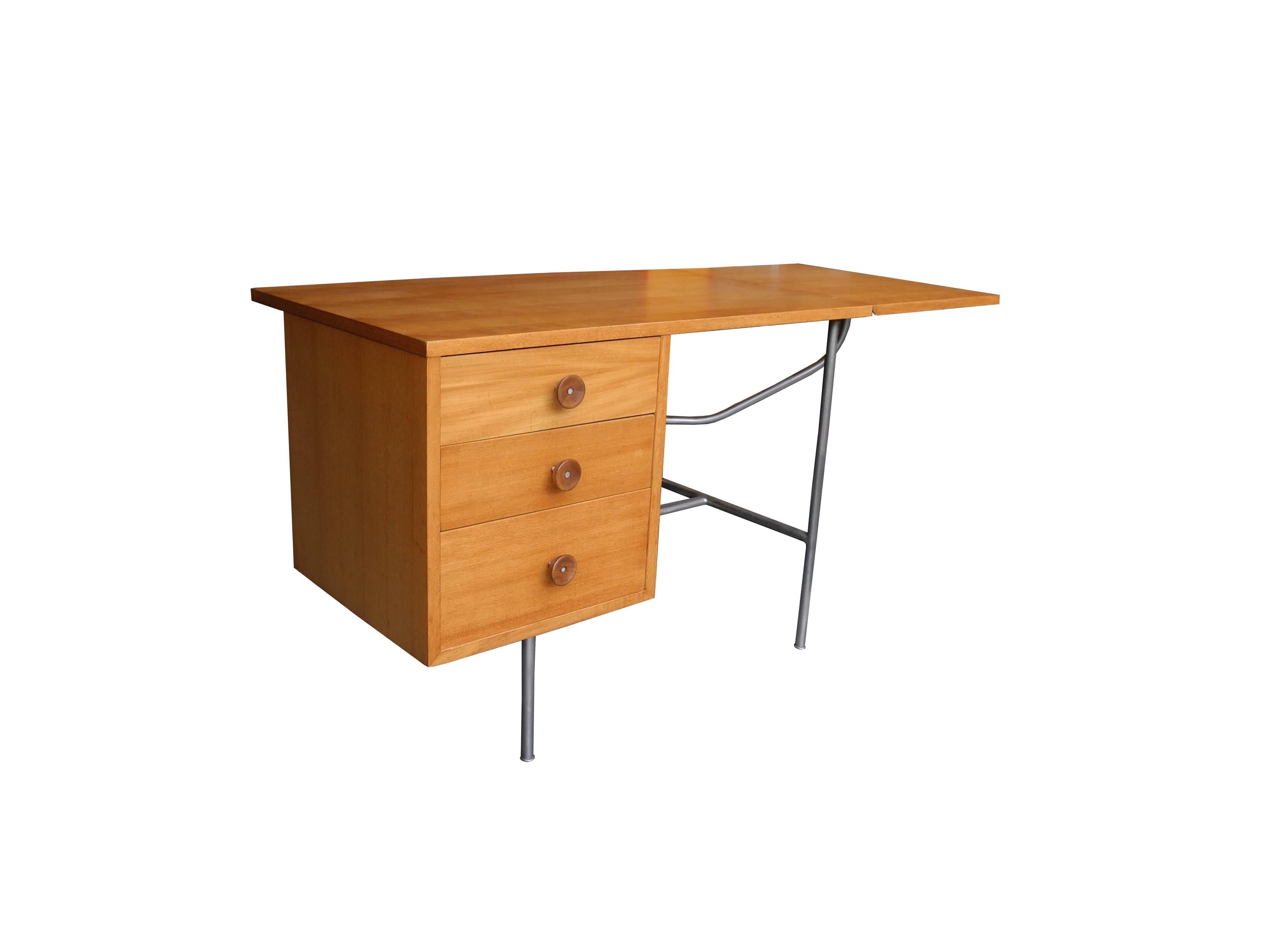 This beautiful blonde bleached mahogany desk with a tubular metal frame is equipped with a flip down extension. Three left hand drawers with the iconic cupcake handles makes the George Nelson desk complete.