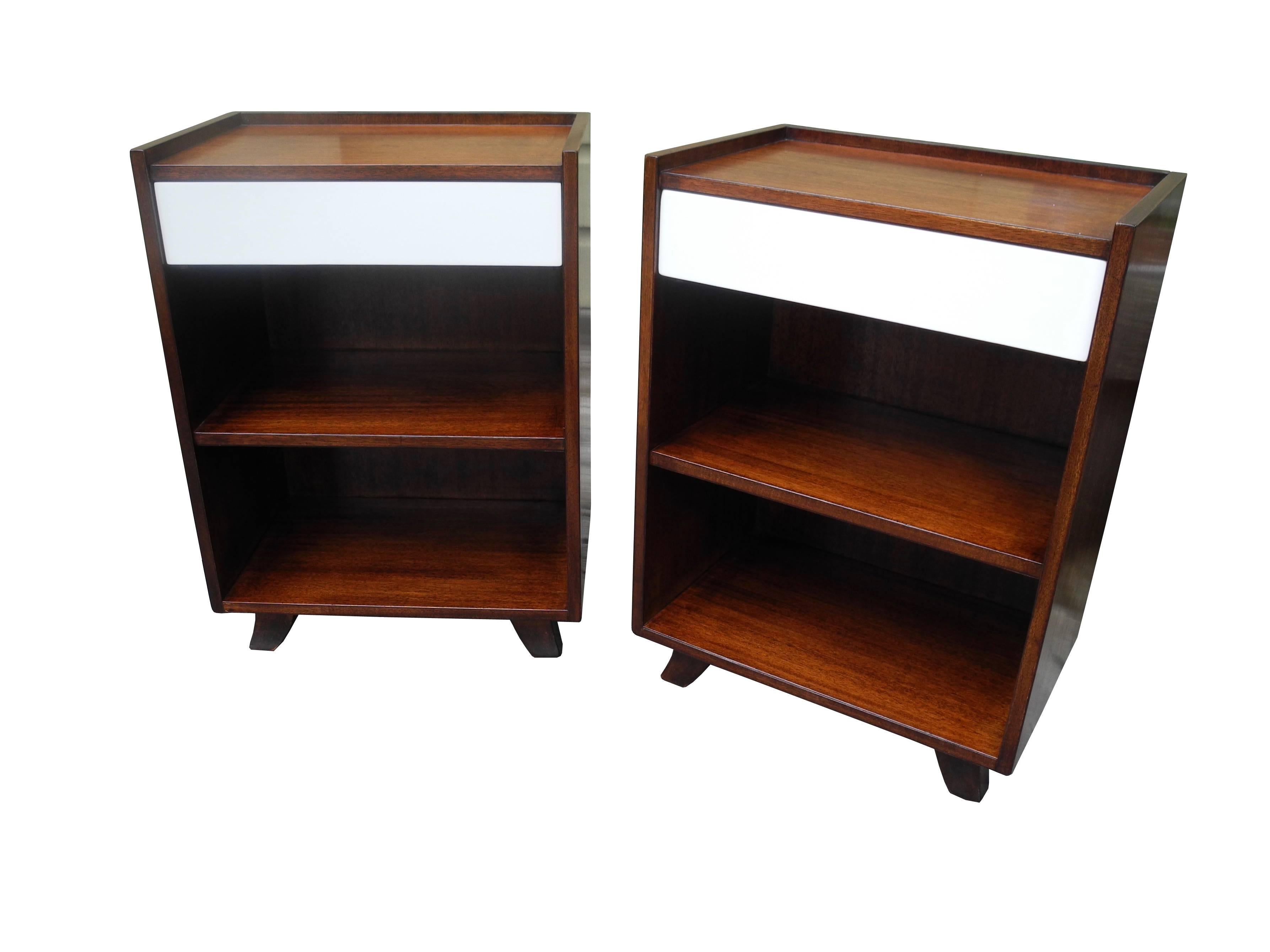 These mahogany nightstands by Gilbert Rohde have one drawer each and a cubby with a shelf.