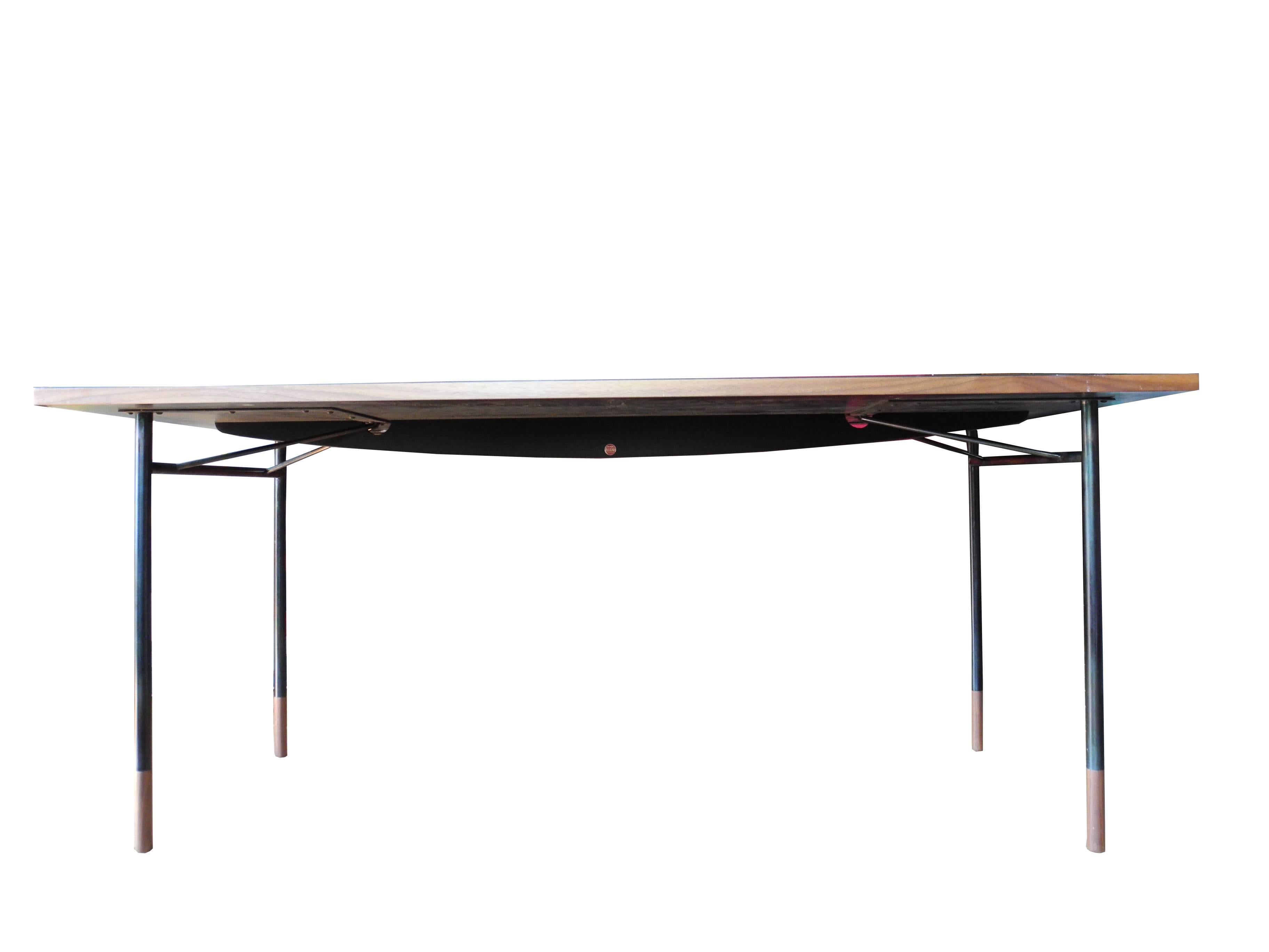 This handsome streamed lined work table or desk is made of steel pipe and walnut sabots. The black work top has a finished wood trim sides to match the legs. This was the work table Finn Juhl designed and used in his studio.