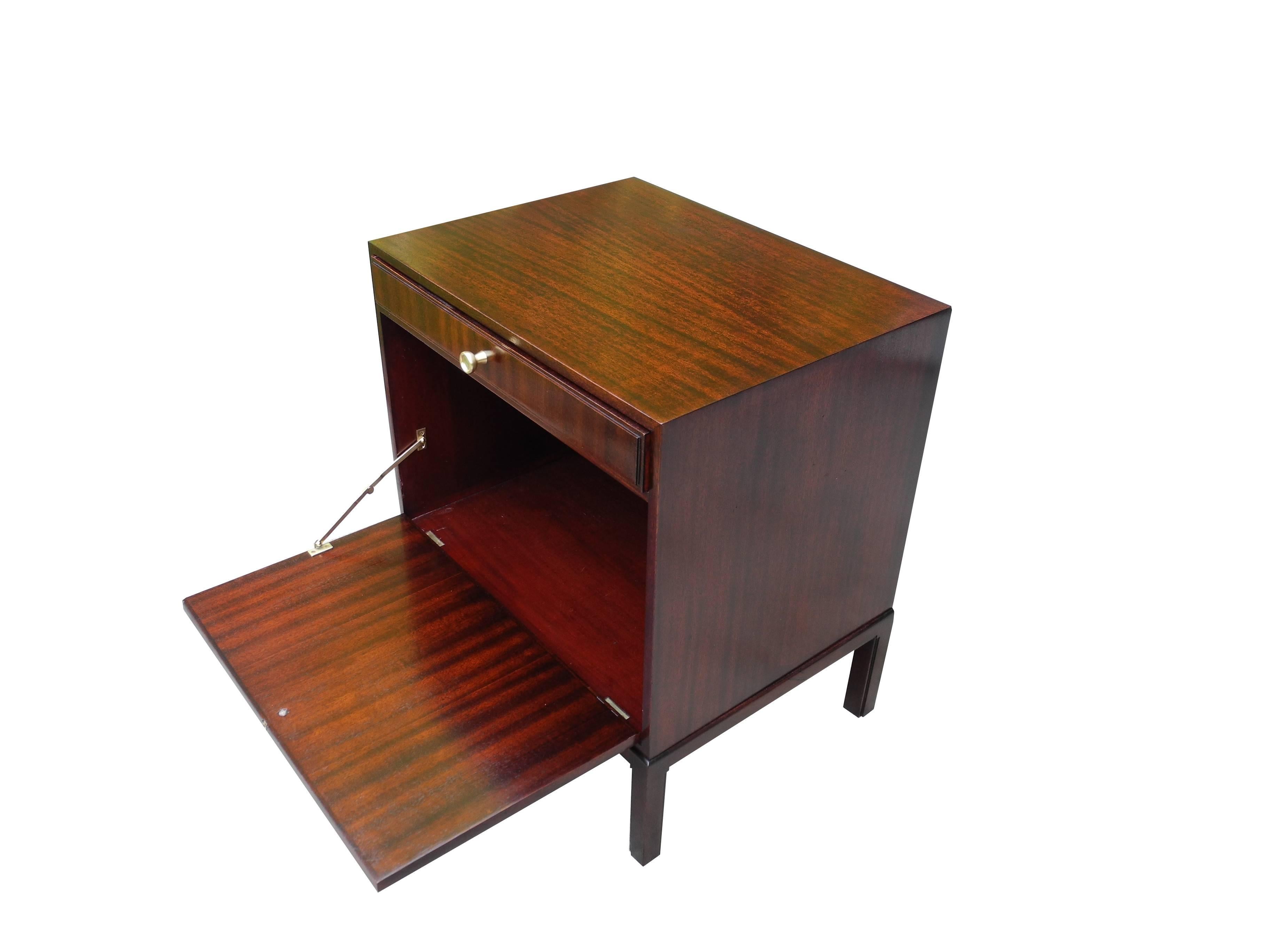 This drop down mahogany little cabinet or nightstand with solid brass hardware is a true charm. Designed by Tommi Parzinger for Charak in the 1950s.
   