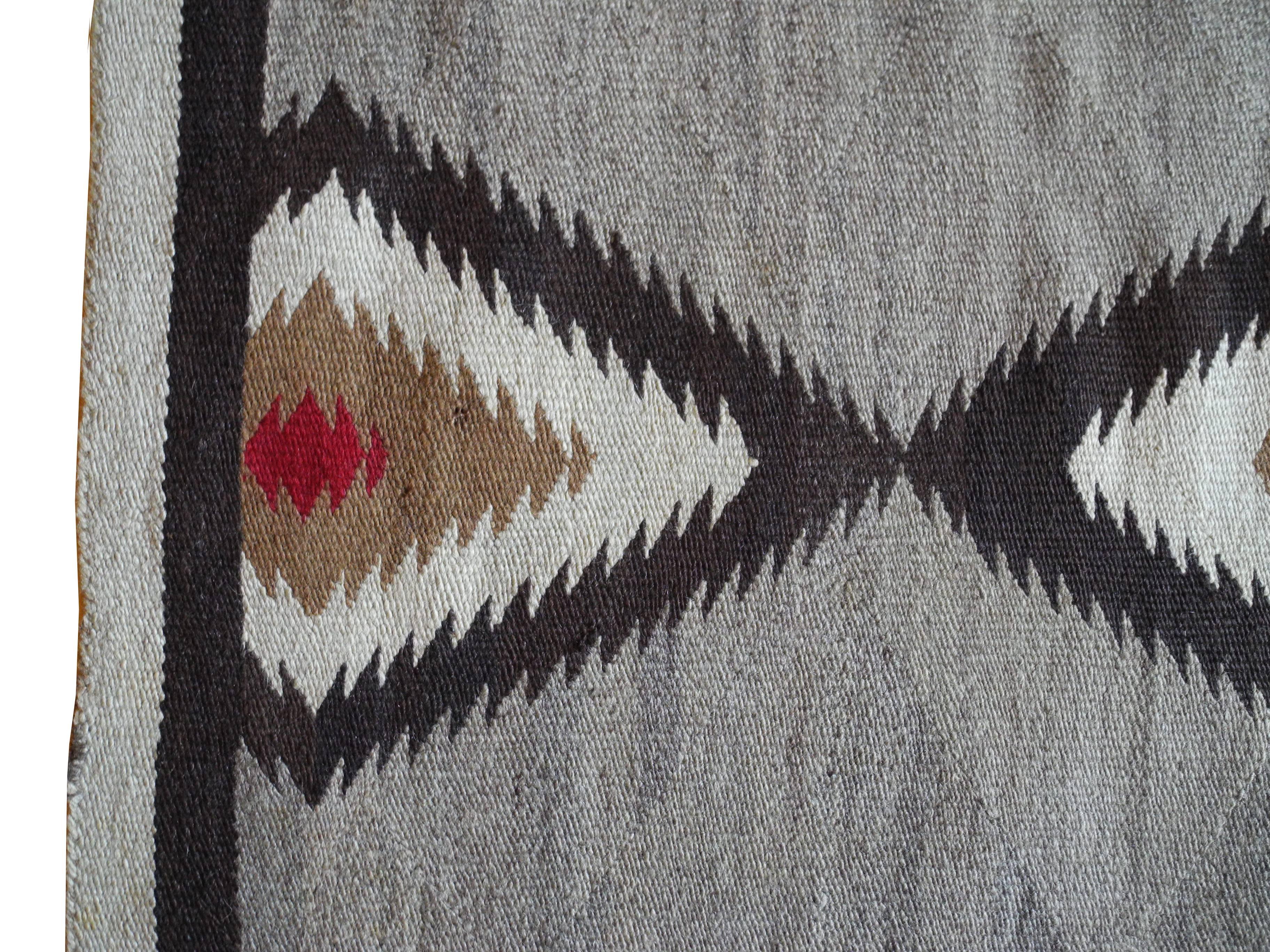 This beautifully handmade woven rug has a central diamond shape with Greek key design on two sides.
Natural grays, browns and ocher colors with died red fiber. The runner measures 67 x 35 inches.