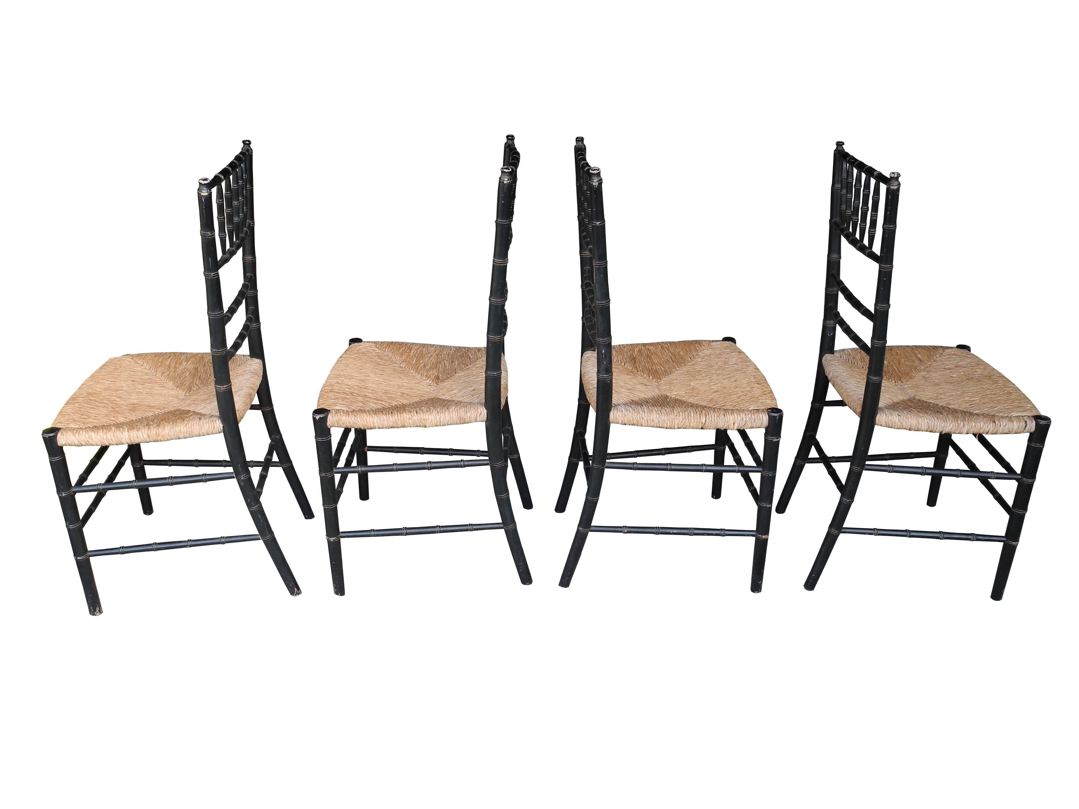 This set of four faux bamboo chairs are made of painted wood frames and rush seats. Slight patina and wear to the frames give them that extra vintage charm.
