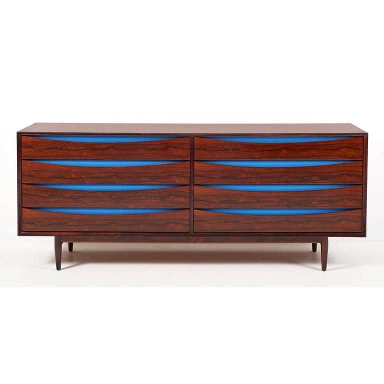 Scandinavian exotic rosewood eight drawer double chest with ellipse shaped finger reveals accented by royal blue lacquered panels. 'Triennale', mod. no. L-32-6. Designed by Arne Vodder for Sibast Mobler. Danish, circa 1950. Literature: George