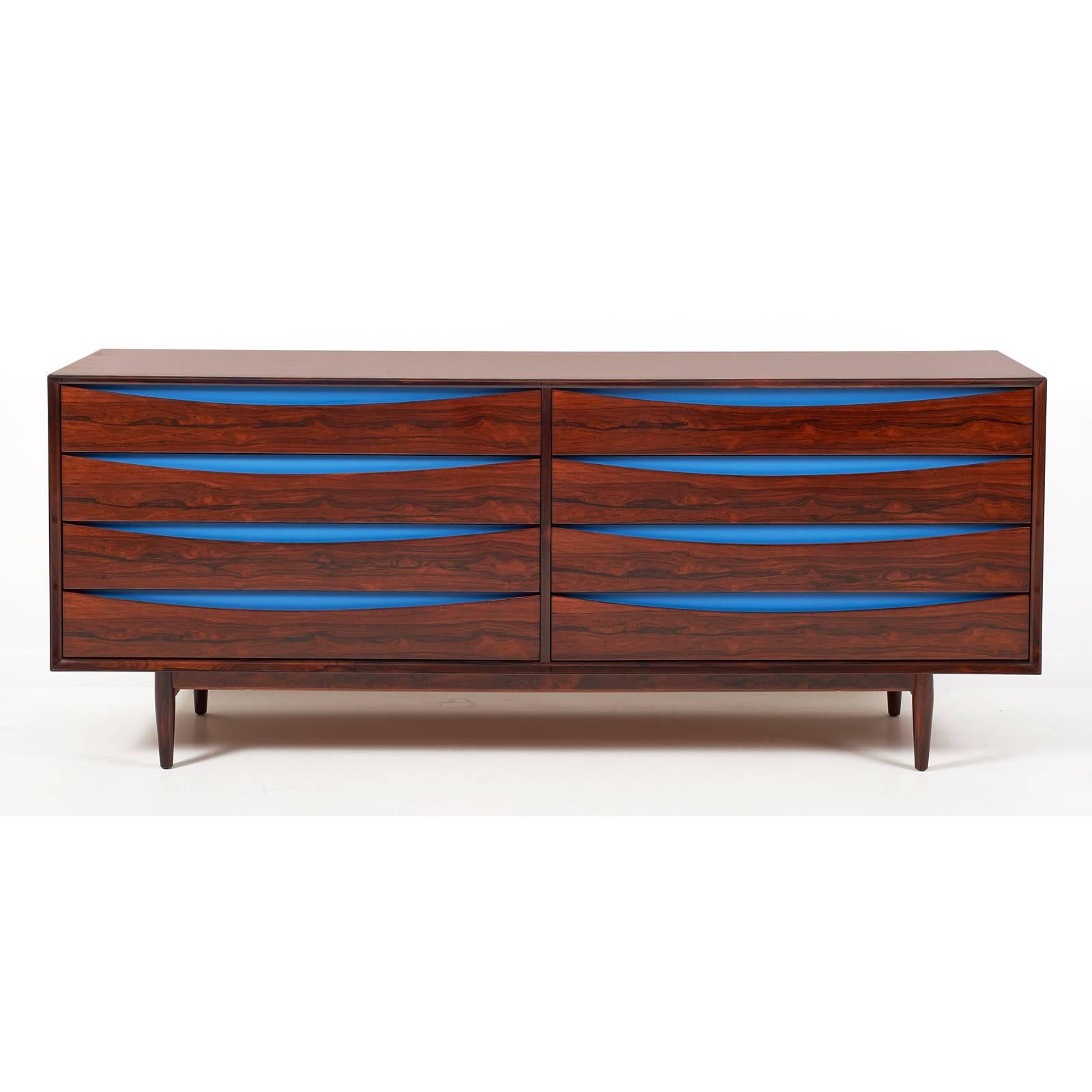 Scandinavian exotic rosewood eight drawer double chest with ellipse shaped finger reveals accented by royal blue lacquered panels. 'Triennale', mod. no. L-32-6. Designed by Arne Vodder for Sibast Mobler. Danish, circa 1950. Literature: George