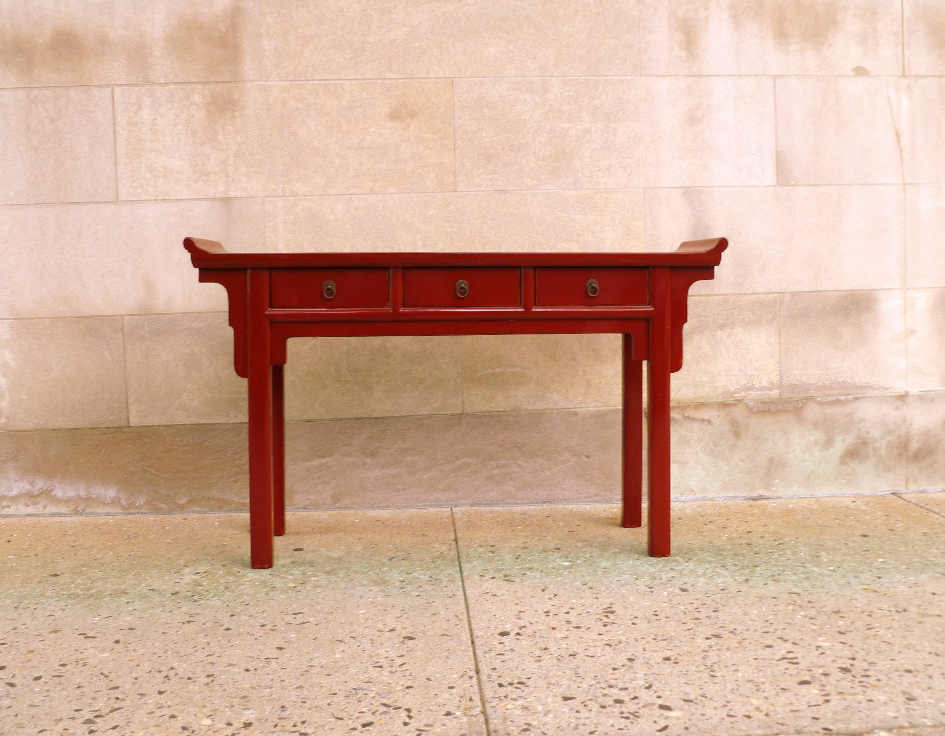 An elegant red lacquer console table with three drawers and everted flanges, beautiful color, form and lines. We carry fine quality furniture with elegant finished and has been appeared many times in 