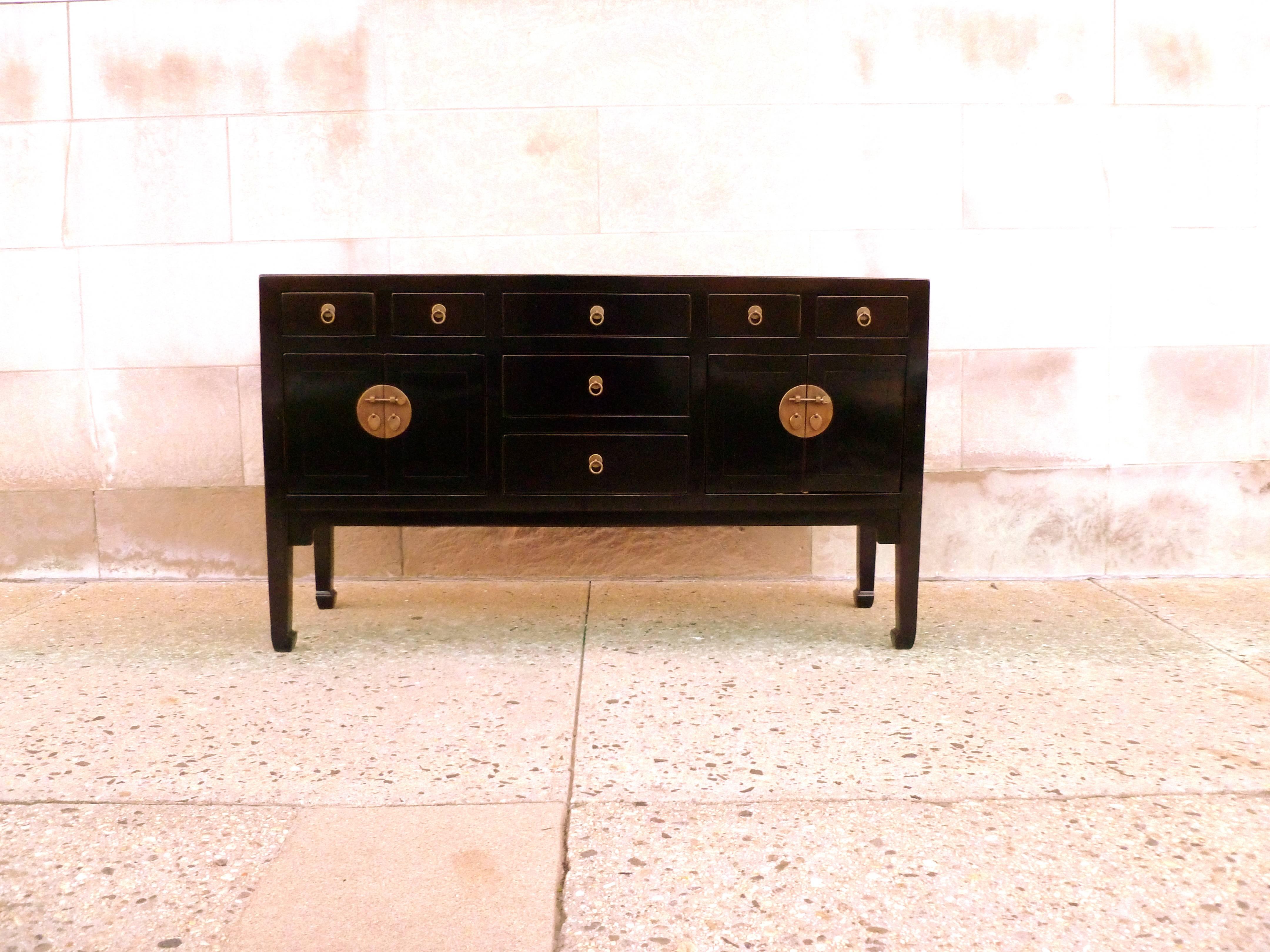 A refined and elegant black lacquer sideboard, framed top supported by square legs and joined by seven drawers and two pairs of doors, brass fitting and ring pulls.
