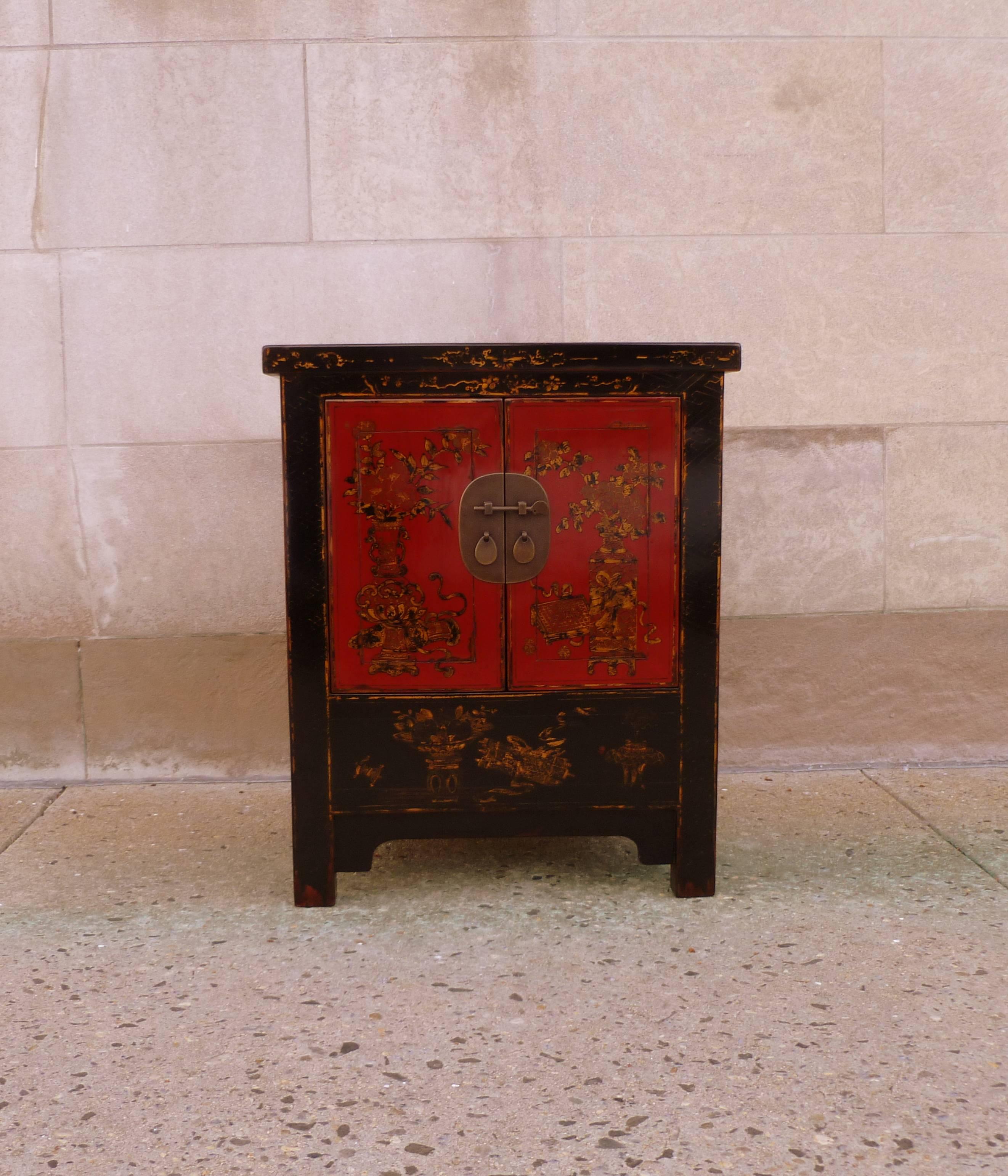 Very elegant chest, of upright form, black lacquer with red lacquer doors muted gold gilt flowers motif on the front side, brass fitting.  We carry fine quality furniture with elegant finished and has been appeared many times in 