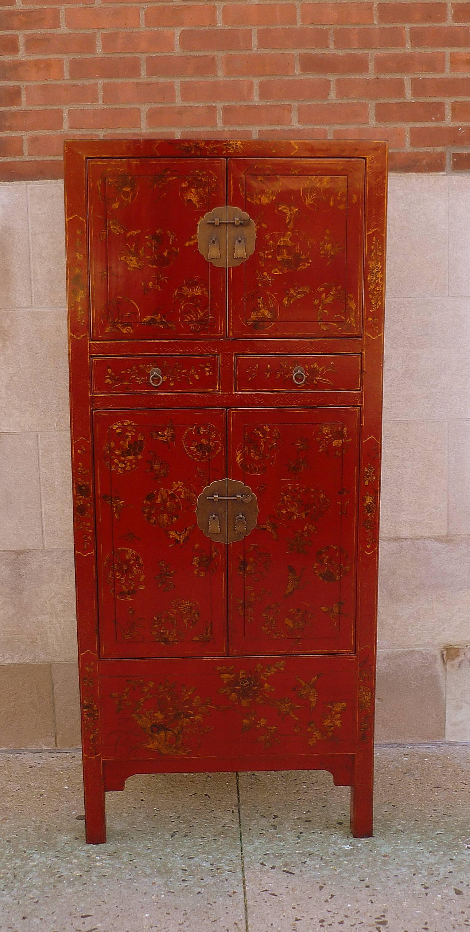 An elegant red lacquer armoire, red lacquer front with fine hand-painted muted gold gilt motif, black lacquered sides, brass fitting. Beautiful colors, form and detail.  We carry fine quality furniture with elegant finished and has been appeared