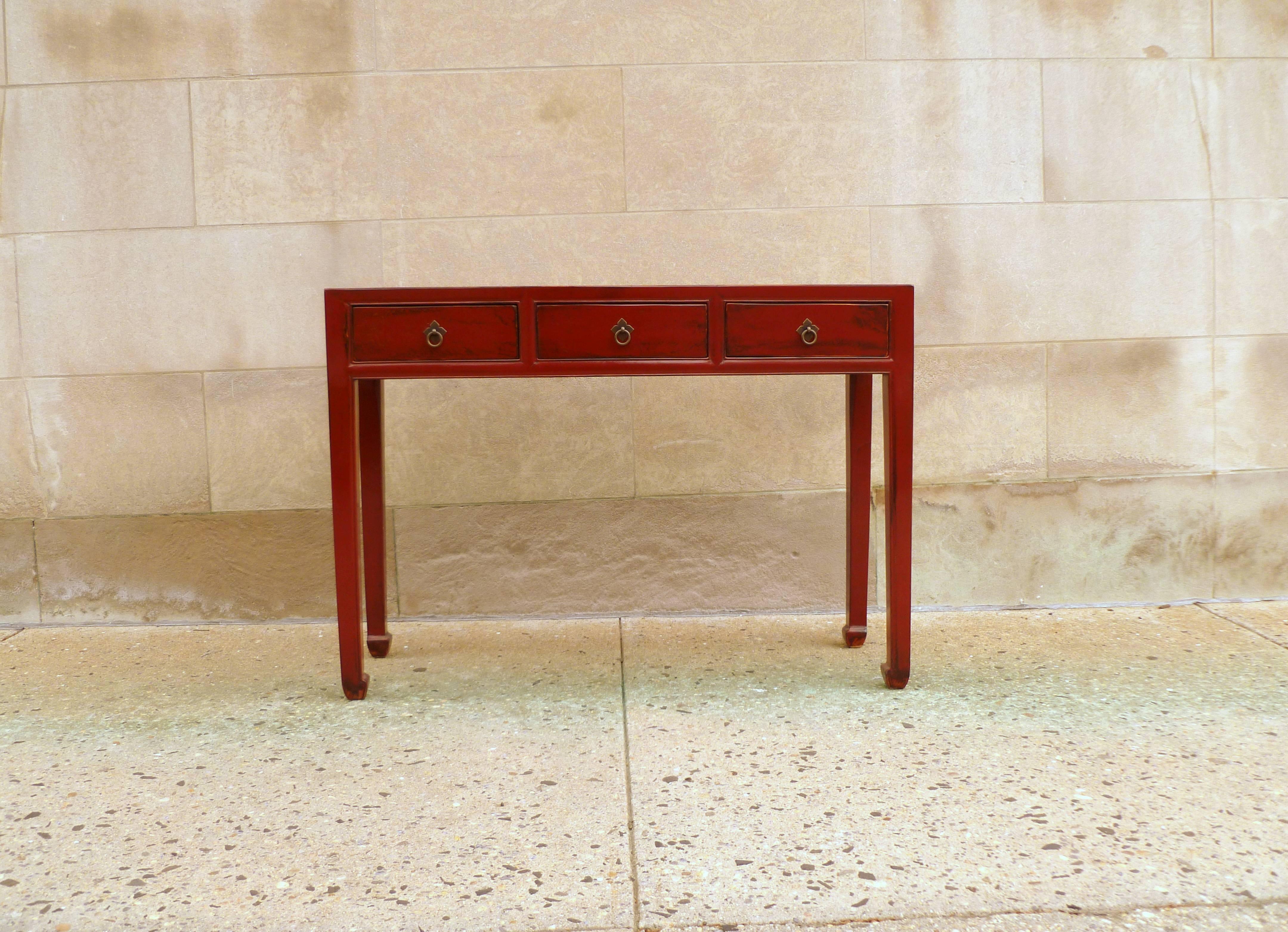 A simple and elegant red lacquer table with three-drawers, brass ring pulls.  We carry fine quality furniture with elegant finished and has been appeared many times in 