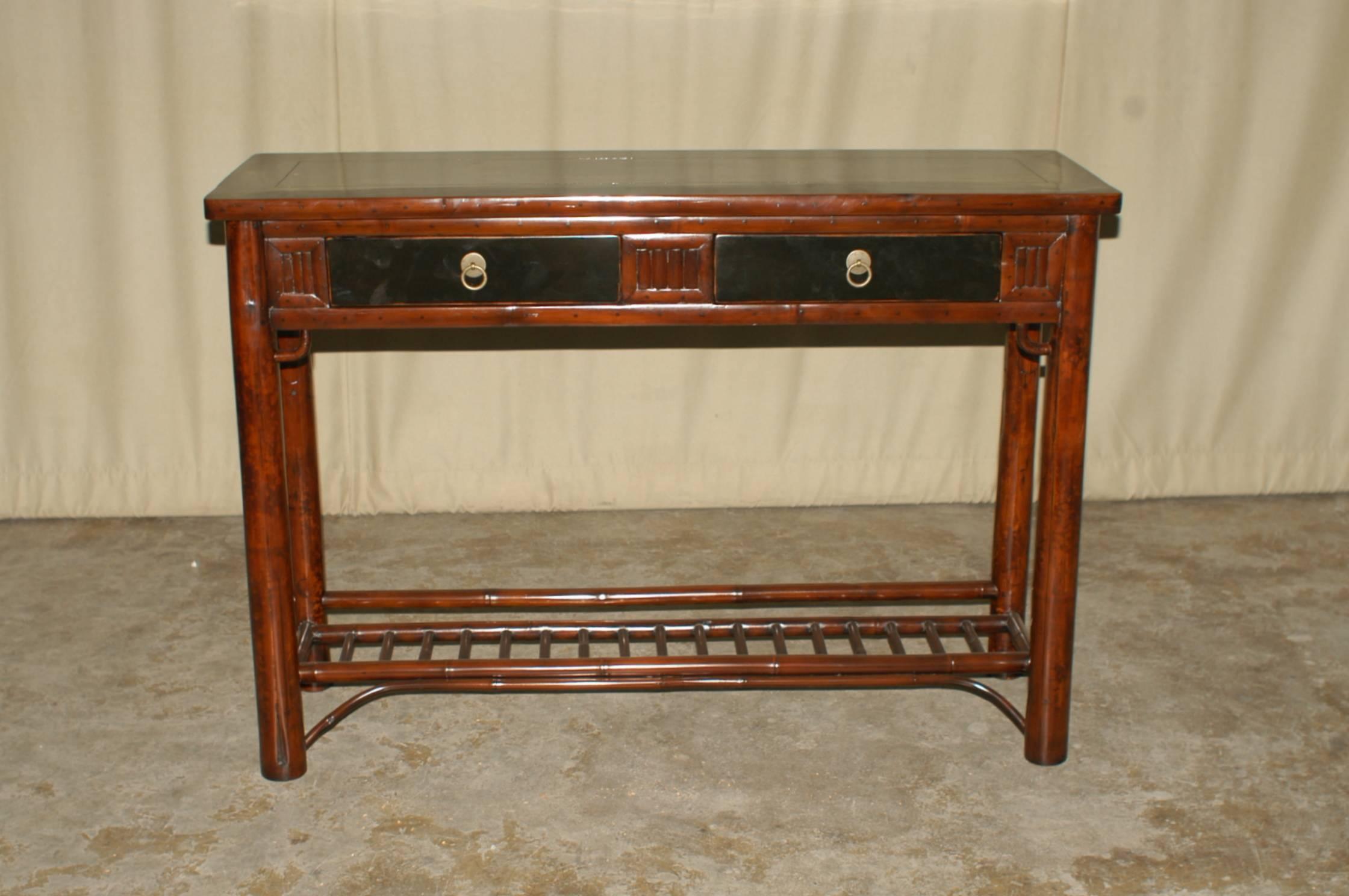 Bamboo console table with black lacquer top with two drawers.