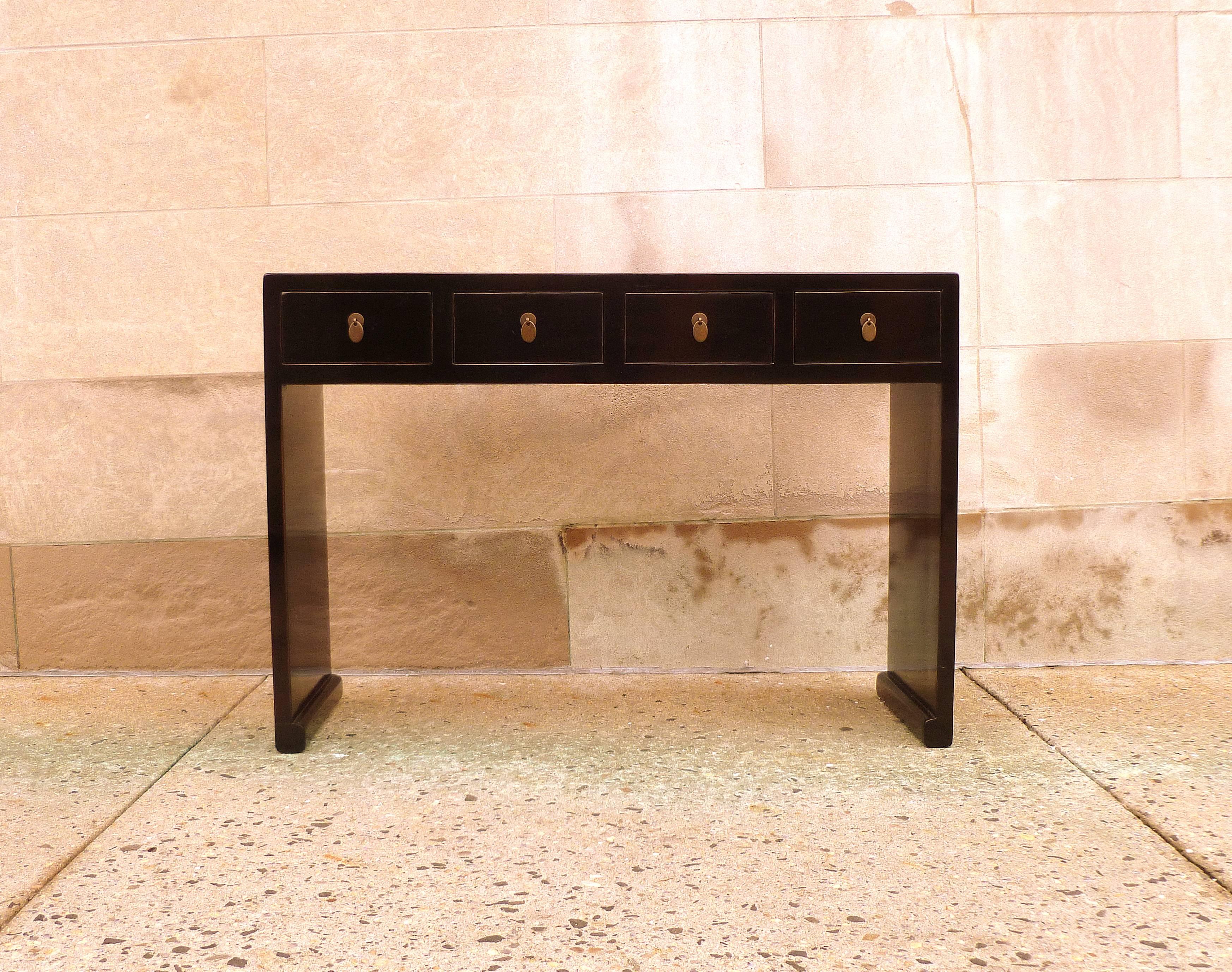 Fine black lacquer console table with drawers and waterfall legs. Very elegant and beautiful form and color.