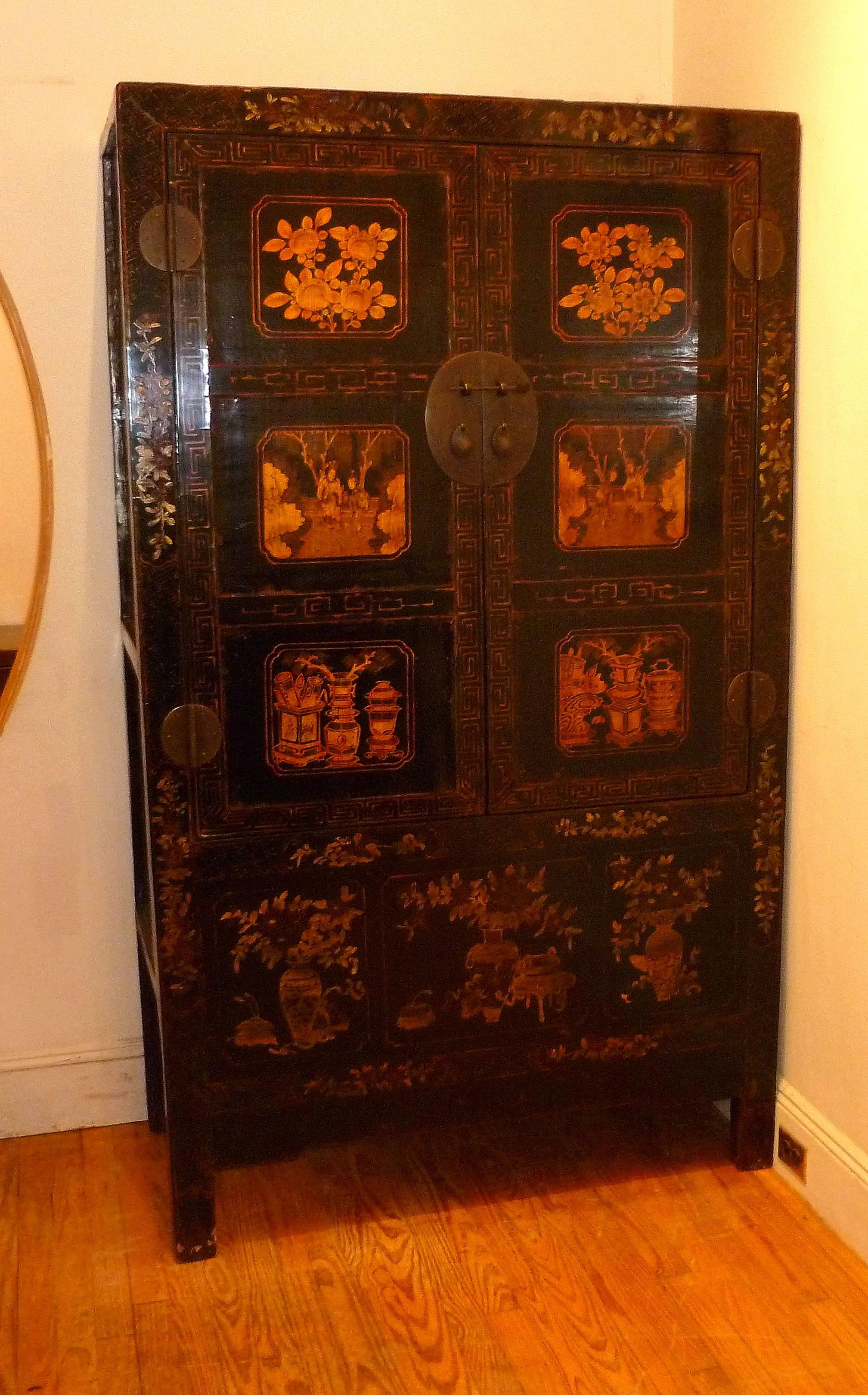 Black lacquer armoire with gilt floral and Peking opera motif. Pair of open door with shelf inside and hidden compartment.