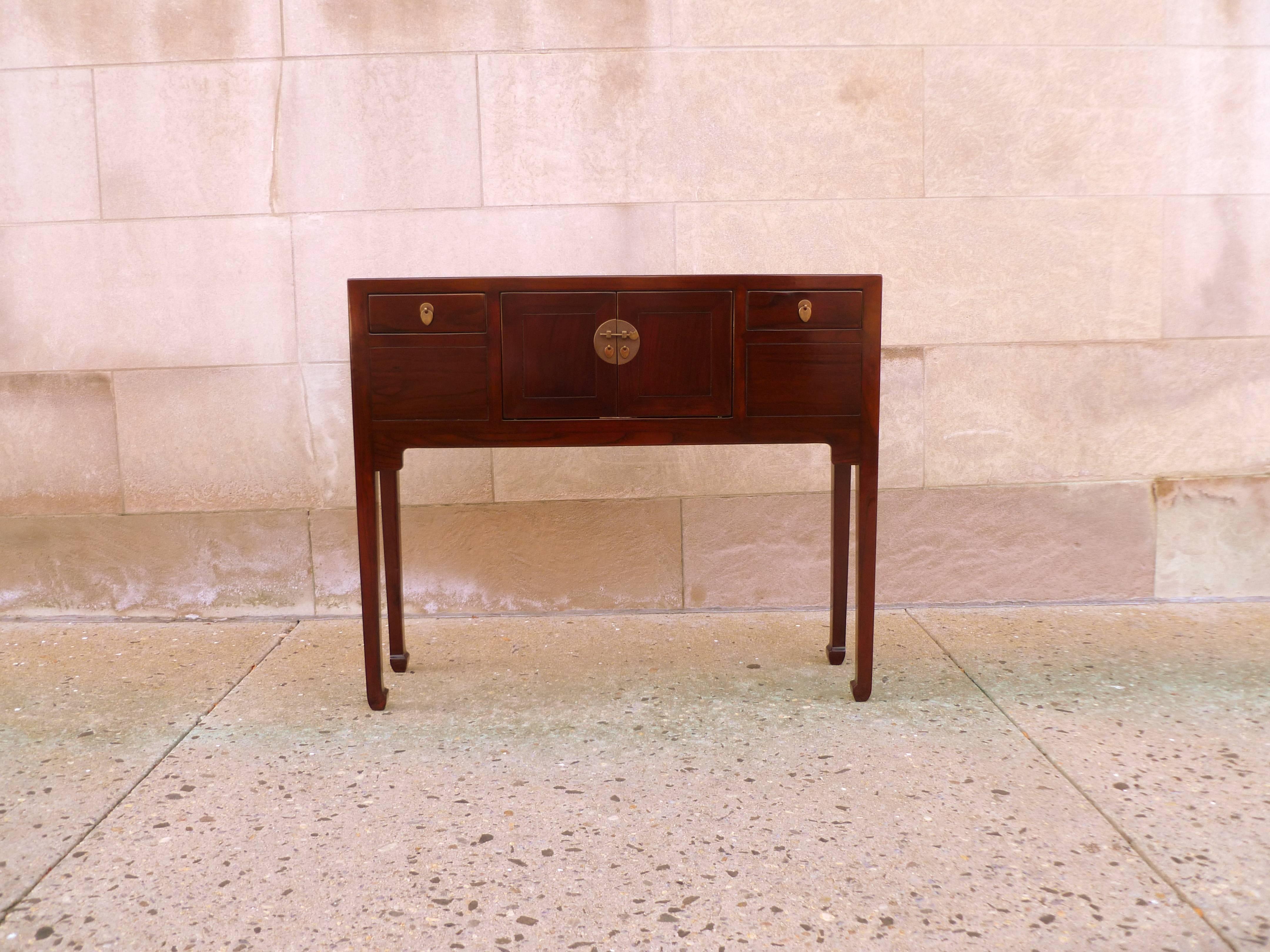 A simple and elegant Jumu table, framed top supported by slender legs and joined by two drawers and a pair of doors, brass fitting, beautiful color and form.  We carry fine quality furniture with elegant finished and has been appeared many times in