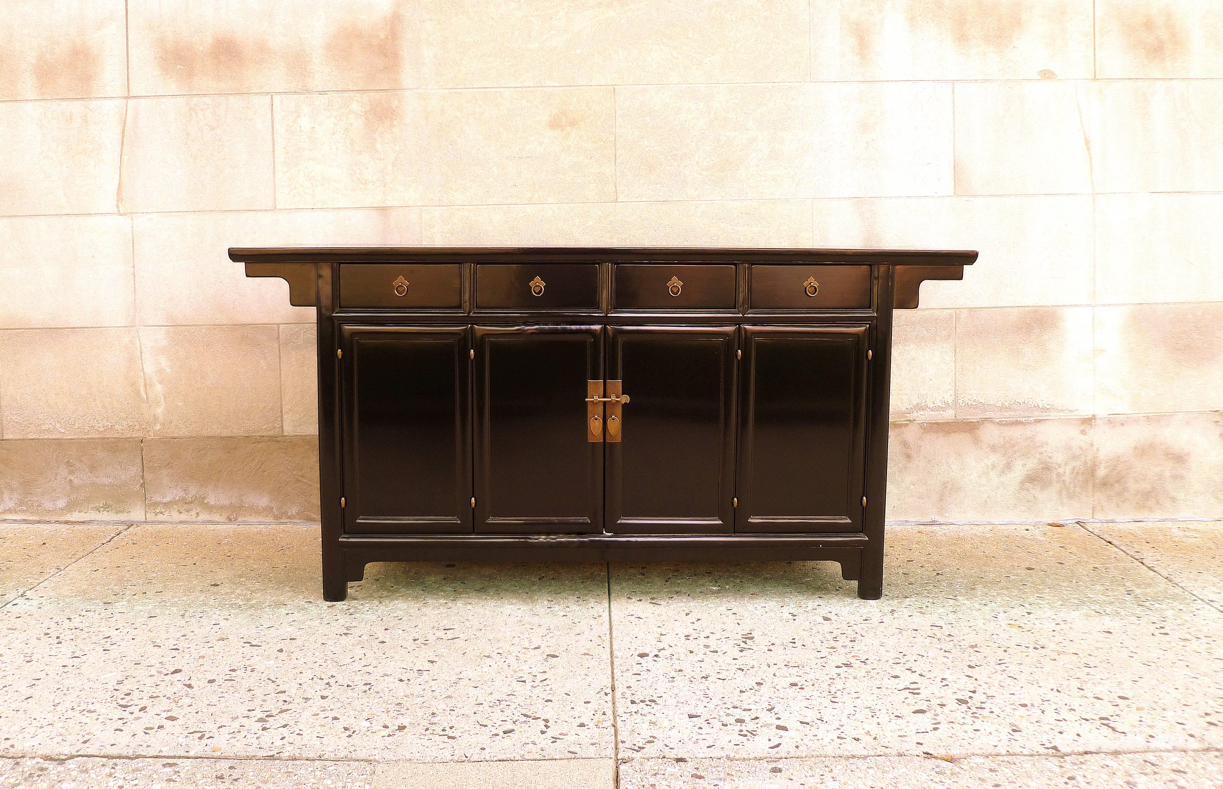 A refined and elegant black lacquer sideboard, with four drawers and a pair of bifold doors, brass fitting, beautiful color, form and lines.  We carry fine quality furniture with elegant finished and has been appeared many times in 