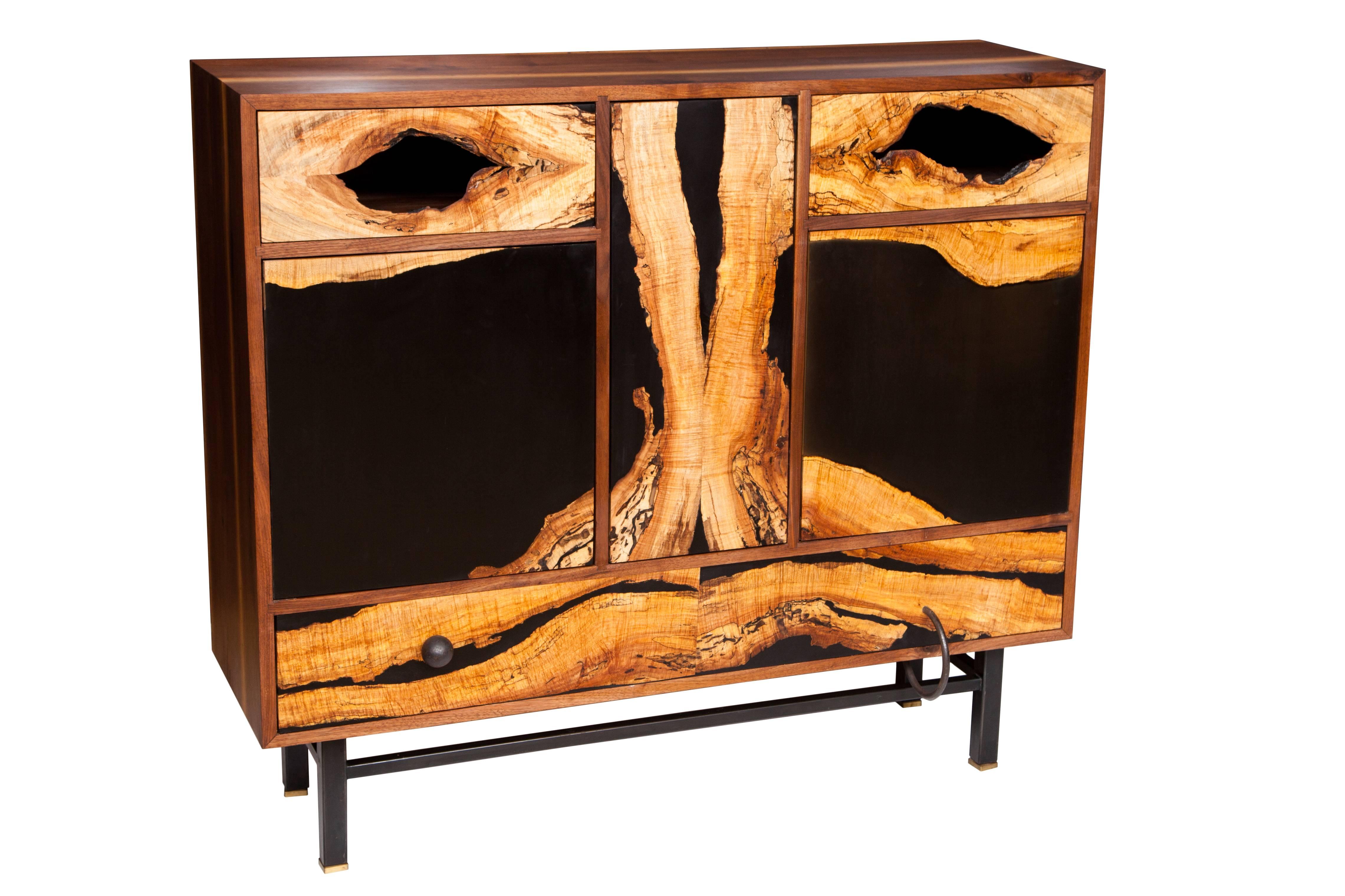 Face cabinet by Don Howell, circa 2010 in solid walnut with mitered and sliding dovetail joinery. Doors and drawers are spalted burled maple inset in tinted resin. Oxidized steel base on solid brass levelers detailed with wrought iron pulls.