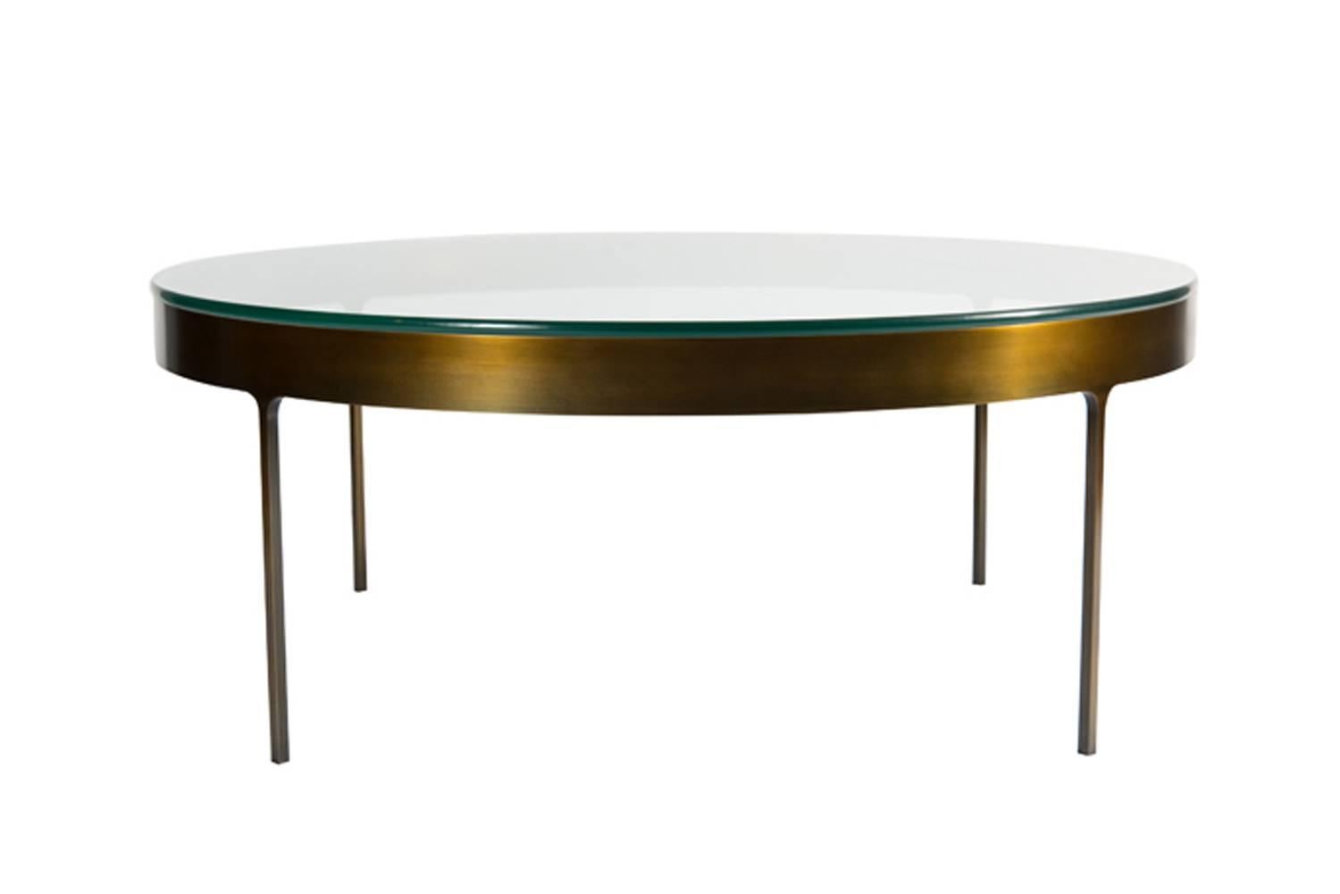 Bronze ring cocktail table with fitted clear glass top. Solid flat bar metal frame with on thin profile legs with interior radius joint detail.

Custom orders have a lead time of 10-12 weeks FOB NYC. Lead time contingent upon selection of