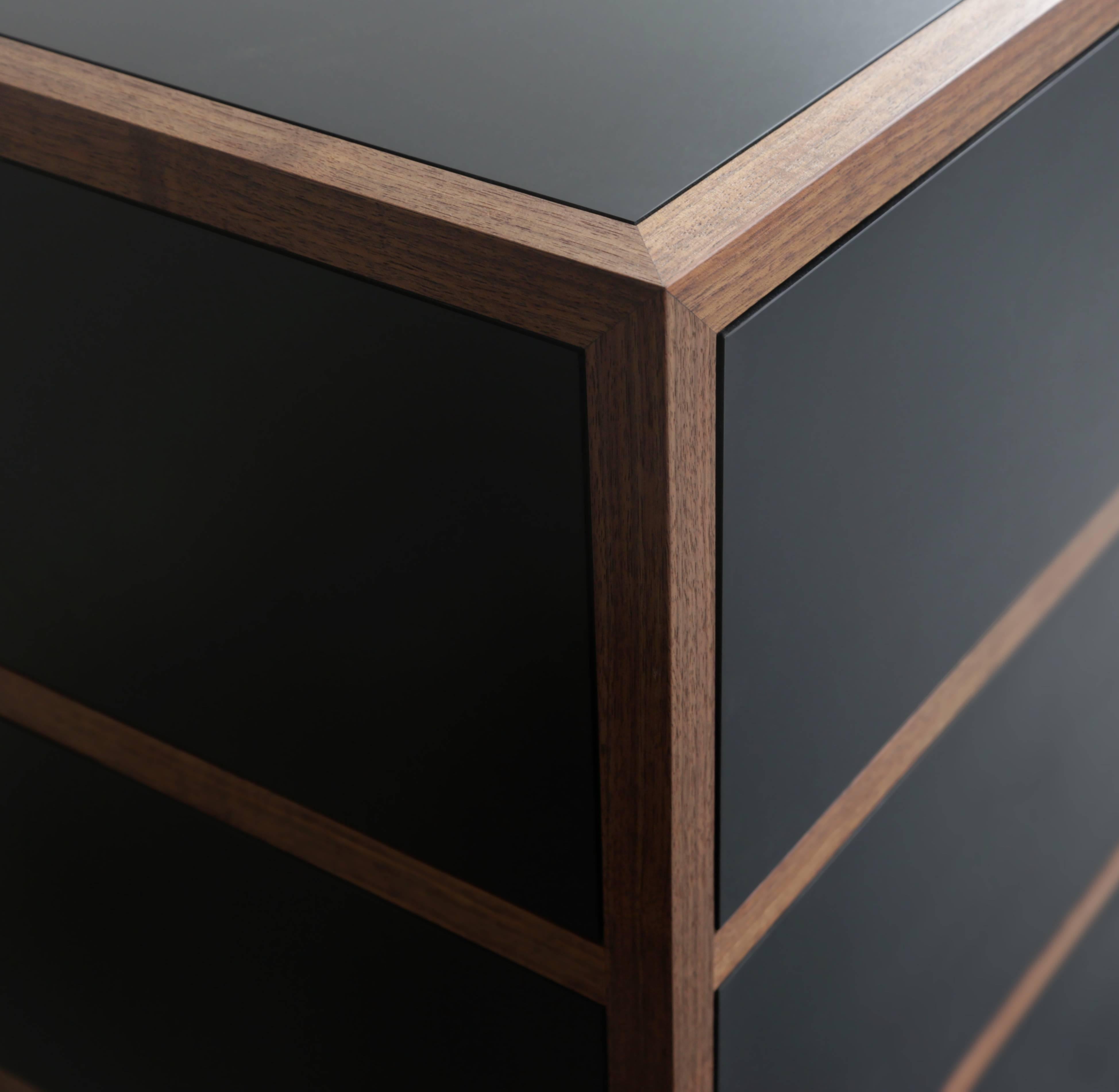 Streamlined dresser with touch-opening drawers . Paper composite and American walnut exterior
American walnut interior triple miter joinery sandblasted blackened steel base FSC certified recycled paper.