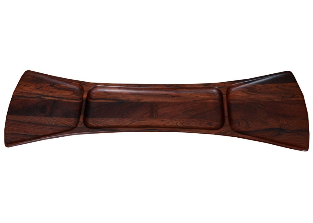 Stunning rosewood tray by Jens Quistgaard for Dansk, circa 1960, signed and numbered. Solid rosewood sculpted tray with inlaid butterfly detail on tapered footed base. Tray is from the rare woods collection.