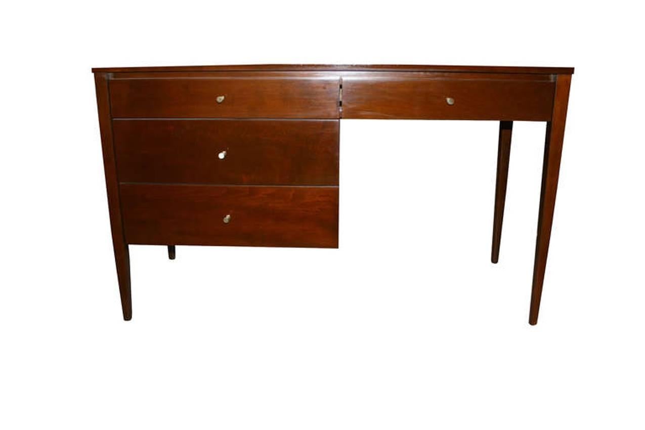 Paul McCobb four-drawer walnut Planner Group desk, circa 1955 in fully restored condition. Solid maple construction finished in a warm walnut tone with original brass drawer pulls.