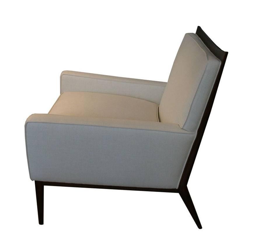 Pair of Paul McCobb 1322 club chairs for Directional, circa 1950s. Solid walnut exposed framework and legs detail this chairs profile with loose feather and foam seat cushion and tight seat back. Rare to market and perfectly restored these are