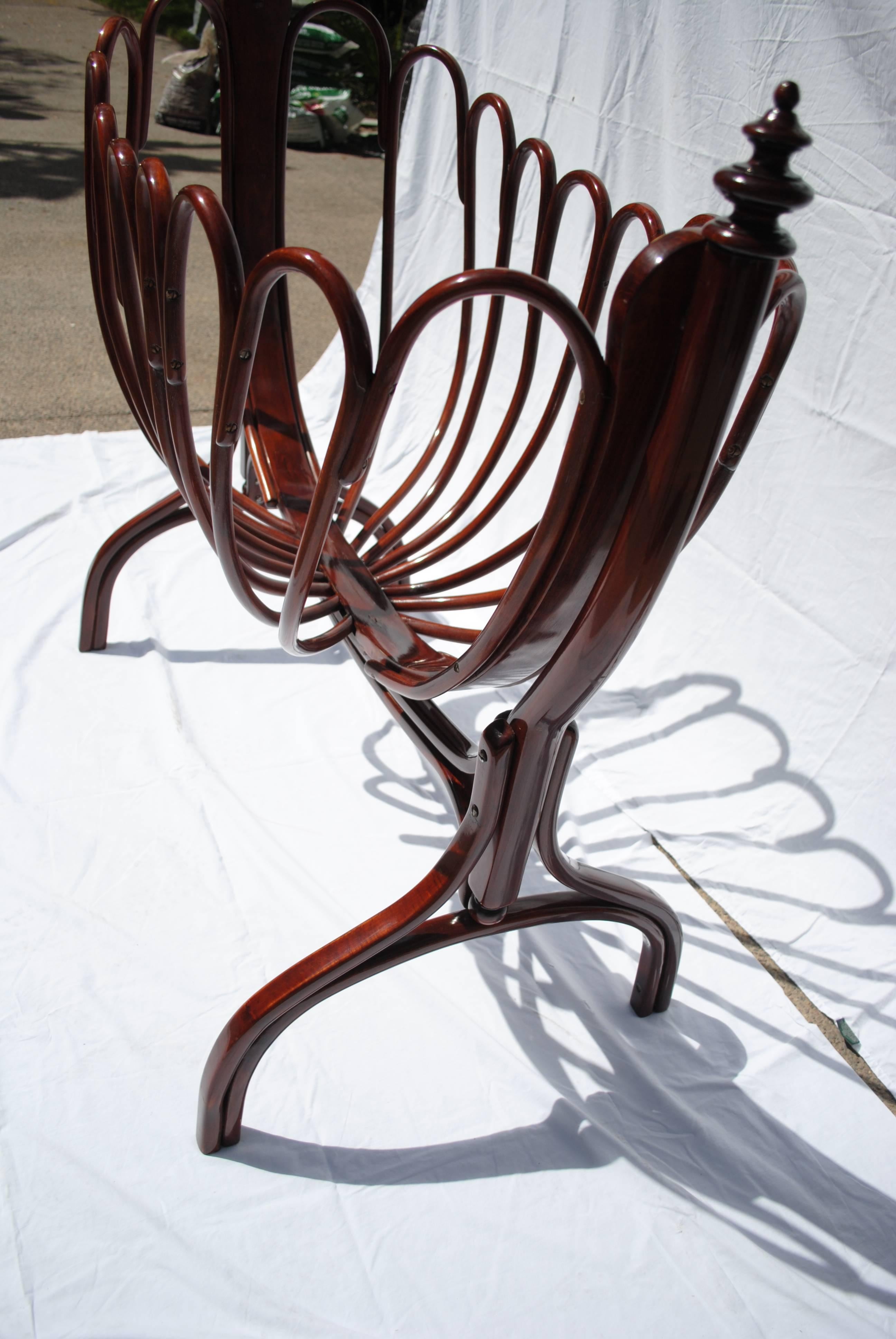 A gorgeous piece in the Art Nouveau style with arching swirl's of glossy mahogany bentwood's. Designed by Jacob and Josef Kohn, the Kohn brothers advanced Thonet's bentwood technique to create designs that are truly works of art. A similar cradle is