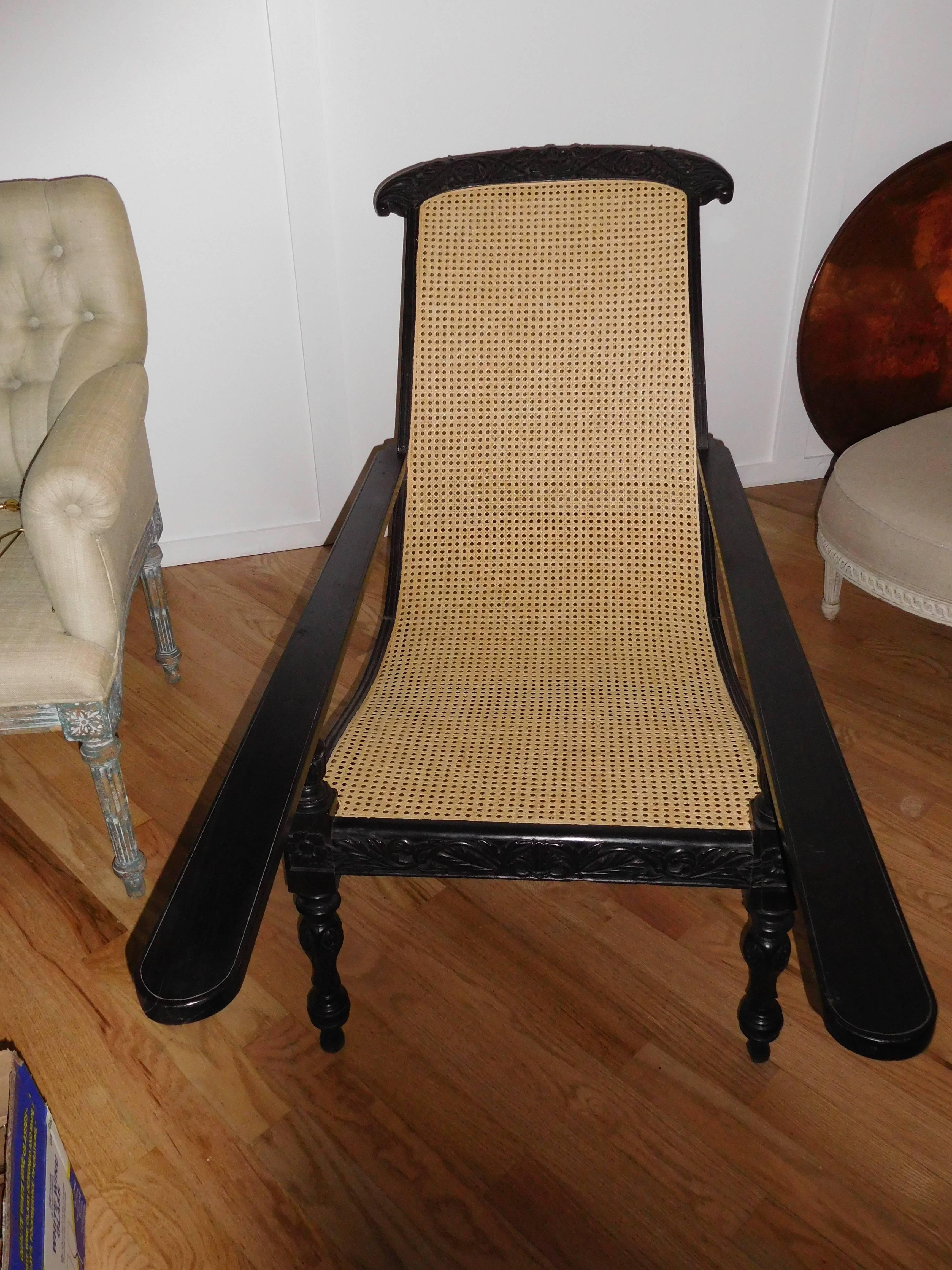 A magnificent Anglo-Indian plantation chair with a hand carved solid ebony wood frame. New caning,immaculate condition.
