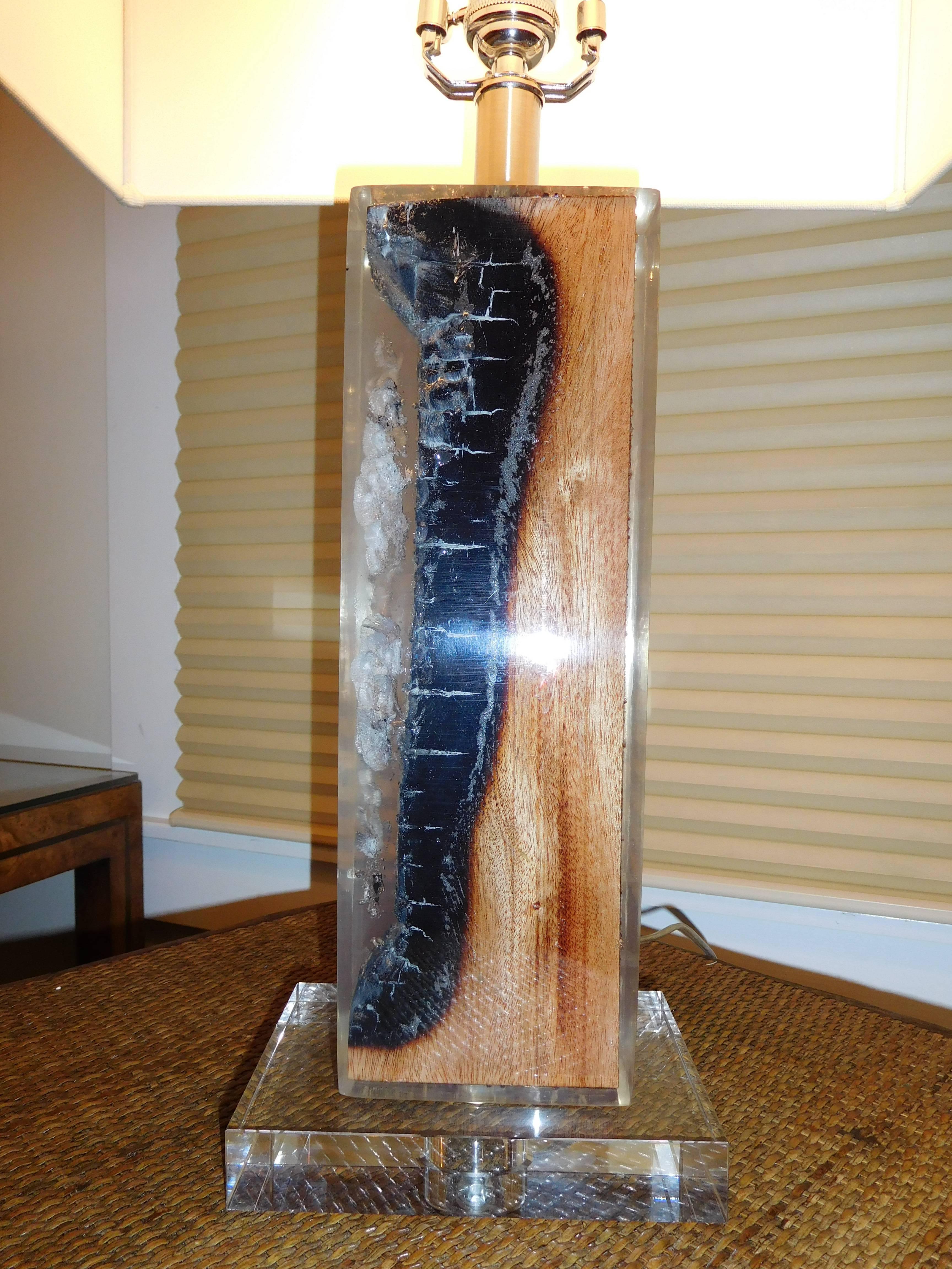 Pair of  organic free edge petrified wood table lamps,  encased in Lucite, includes the rectangle  shades..
Three way switch, beautiful in any setting.