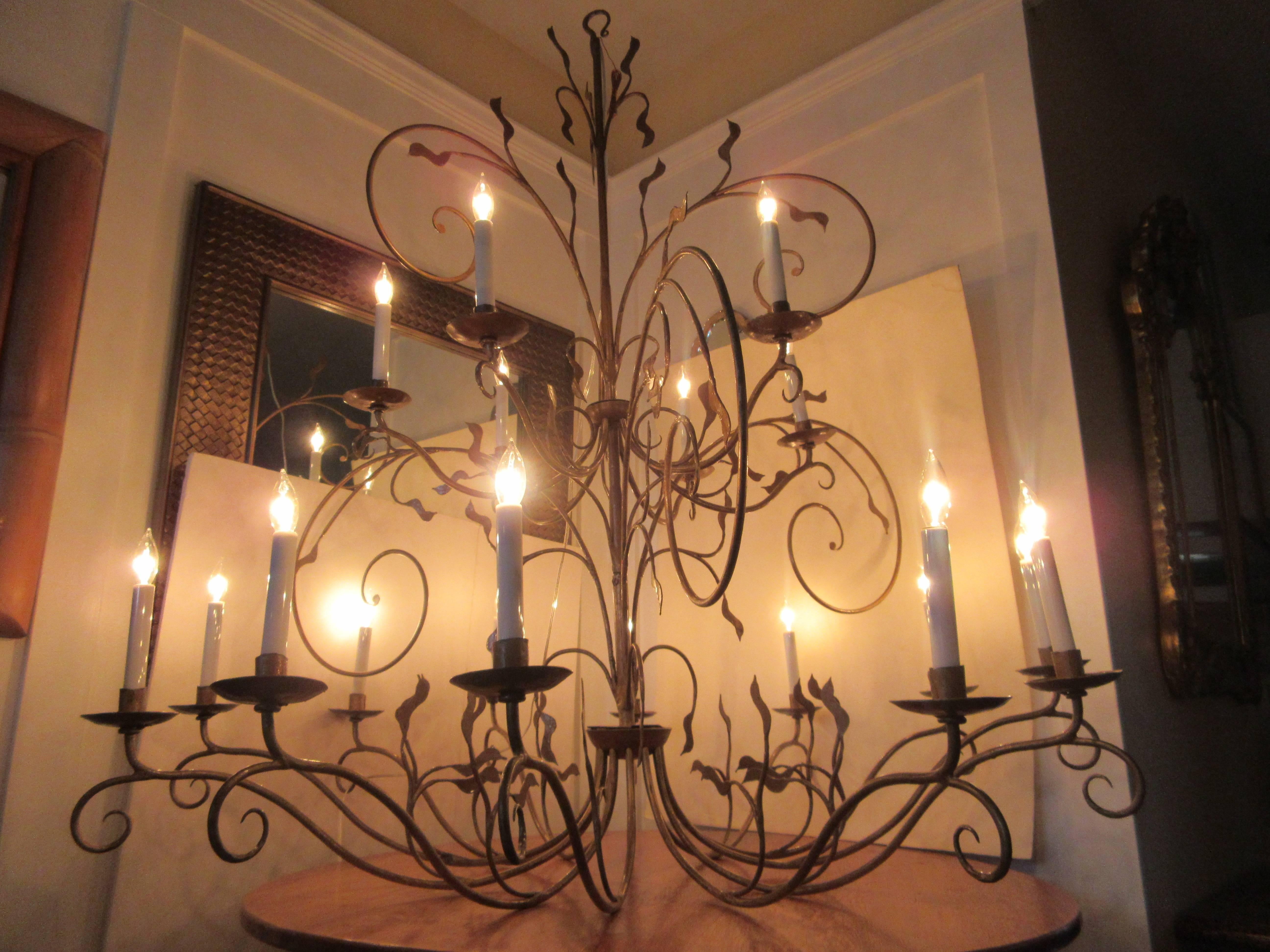 A lovely French Art Nouveau chandelier. New to code wiring, with ceiling fixture, the drop measurement is without a chain. There eighteen arms, all decorated with well detailed leaves. The finish has worn to an antique gold matte finish.