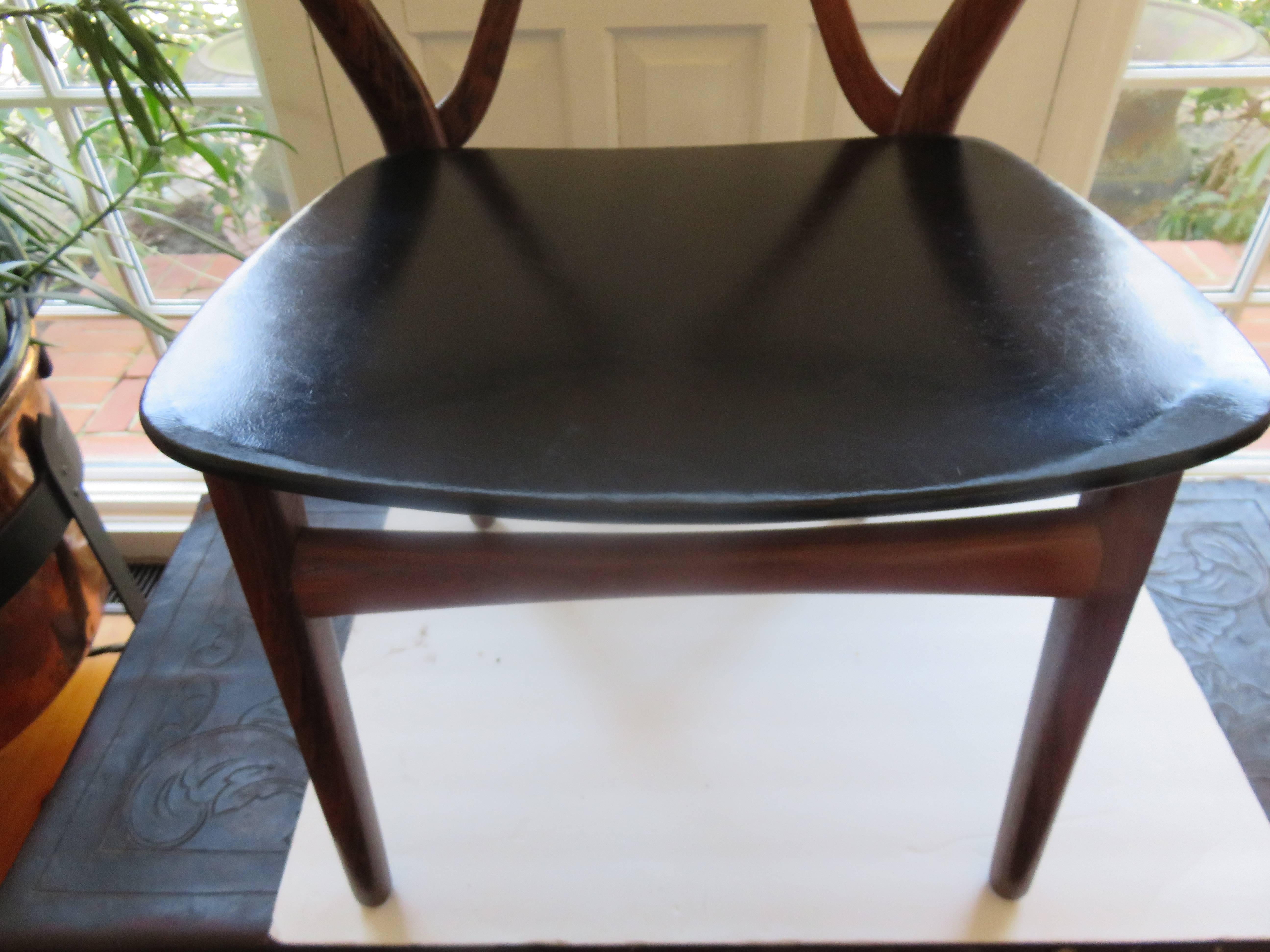 A Danish modern Mid-Century teak dining room chair by Kjjaernulf Henning for Bruno Hansen. Lovely original condition, black faux leather seat.