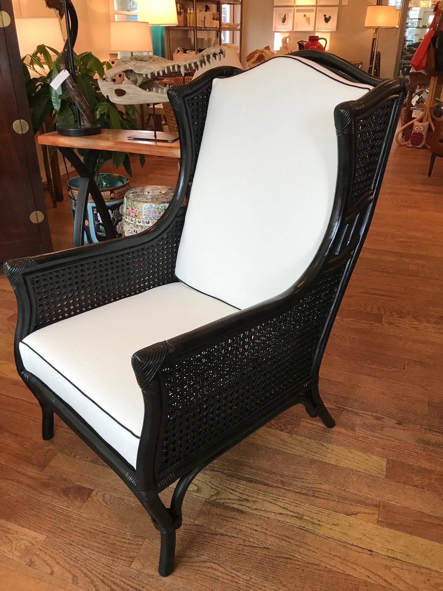 Beautifully restored ficks and reed bamboo and cane armchair with ottoman.
Upholstered in a white weave sunbrella fabric with black single welt, zippered cushions, all new filling.
The ottoman measures 24 inches wide and 18 inches deep, seat