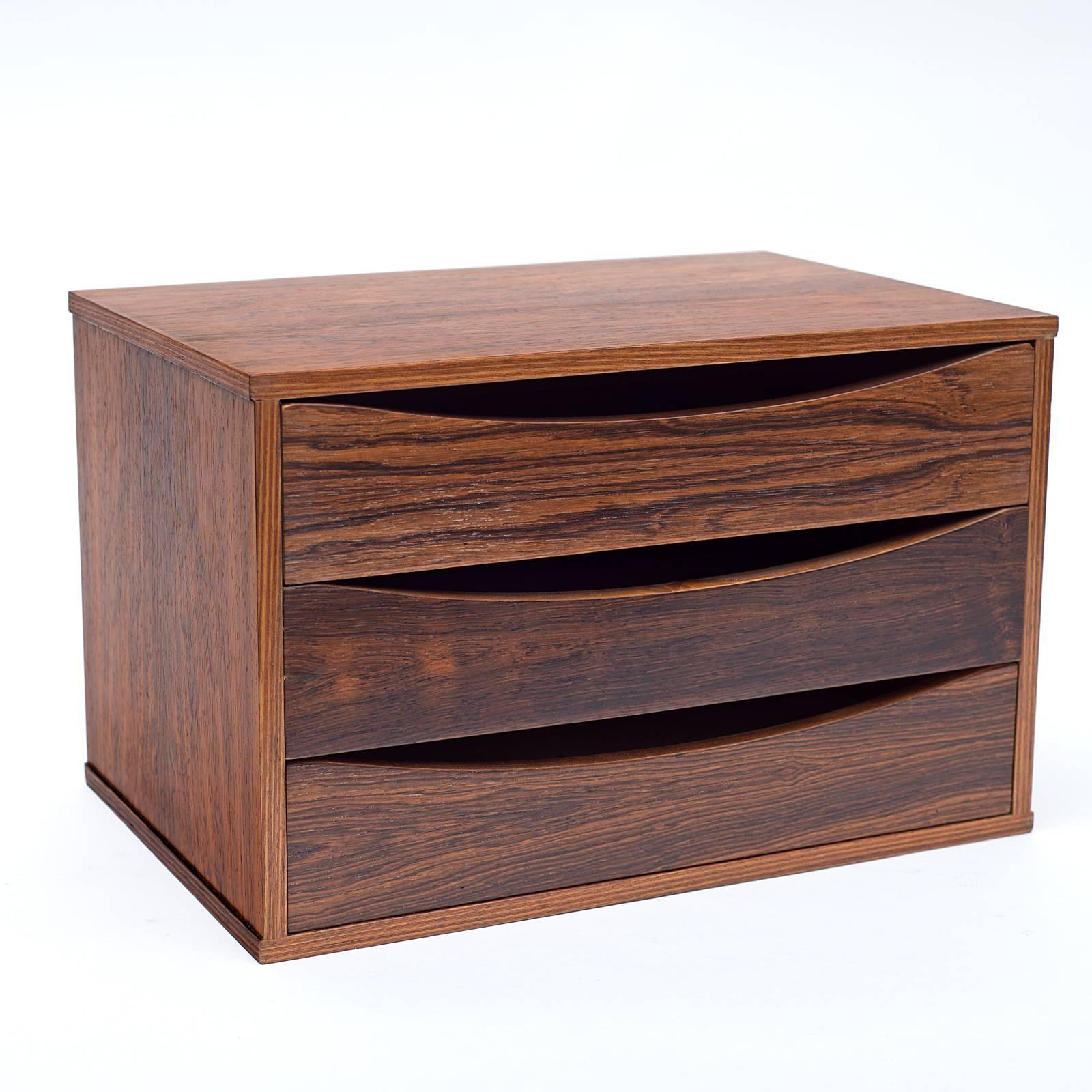 A practical and attractive small chest of drawers that could be used for a variety of purposes. Usually found in teak this is an outstanding rosewood version.