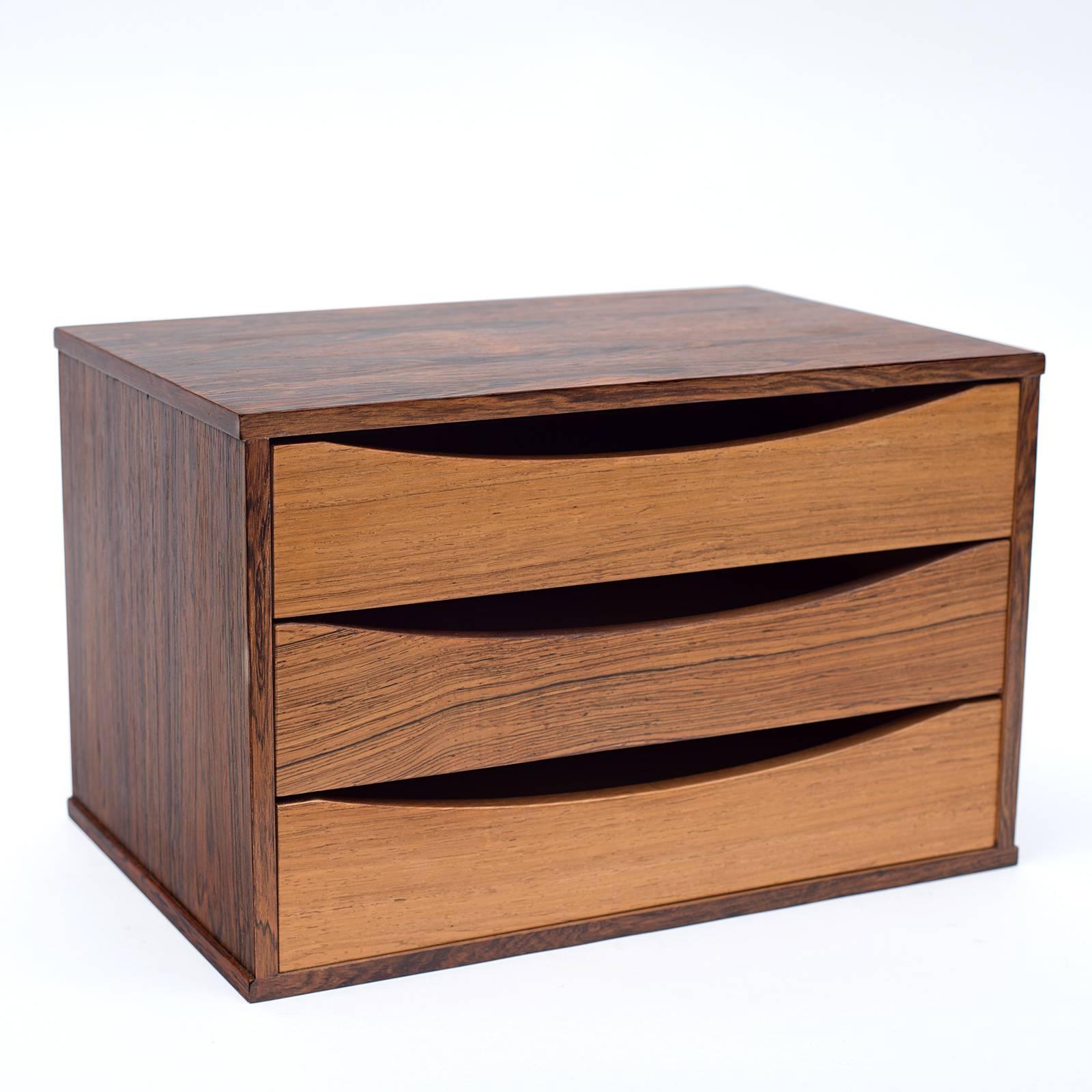 A practical and attractive small chest of drawers that could be used for a variety of purposes. Usually found in teak this is an outstanding rosewood version.