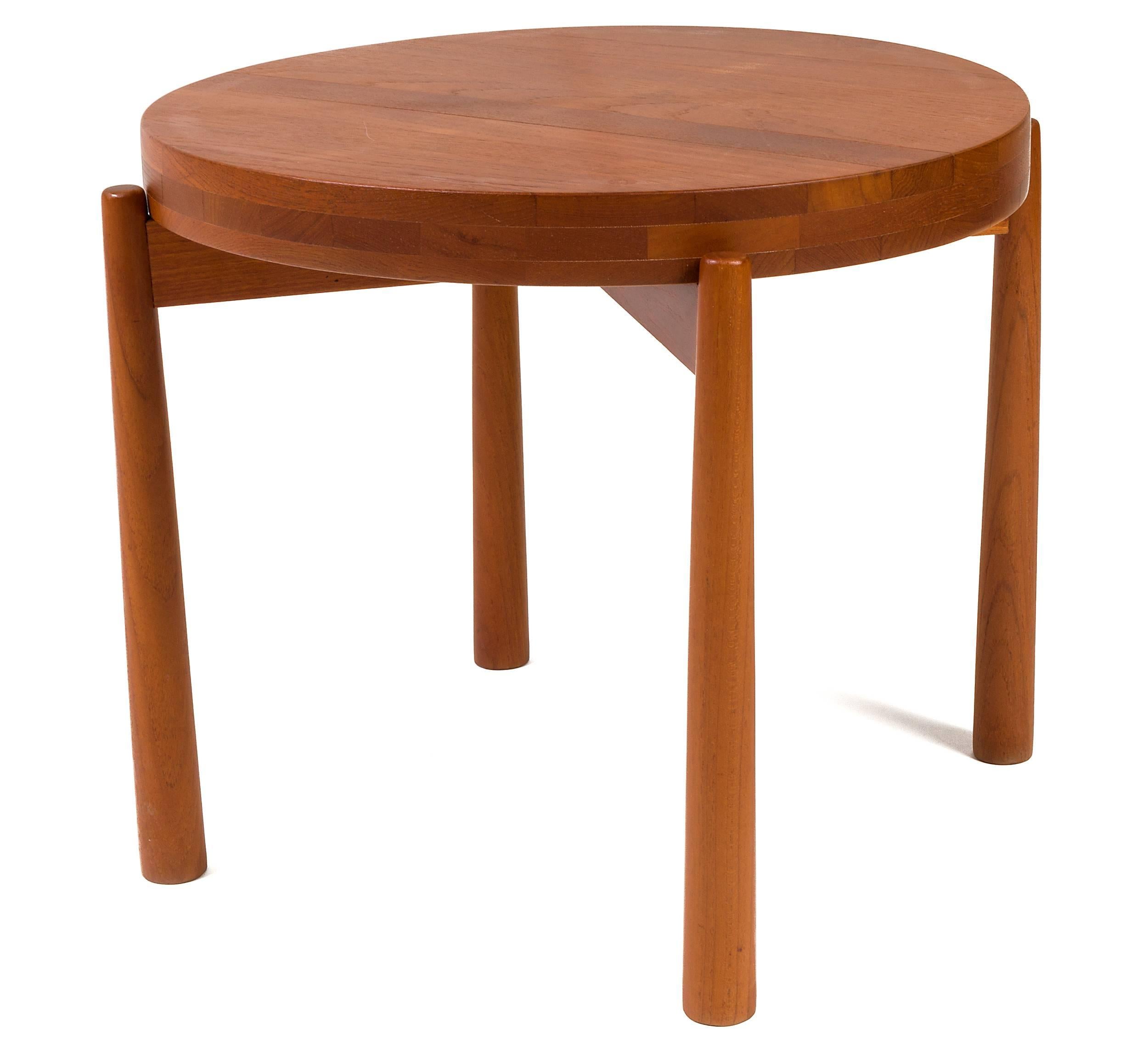 A solid staved teak tray table, in the style of Jens Quistgaard. This piece is made of solid staves of teak laminated together to form a butcher block style construction. The tabletop is reversible and is concave on one side and flat on the other.