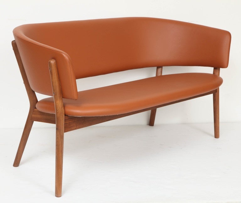 Nanna Ditzel 1923-2005. Free-standing shell sofa with seat and back upholstered in cognac leather, walnut frame. Designed in 1952.