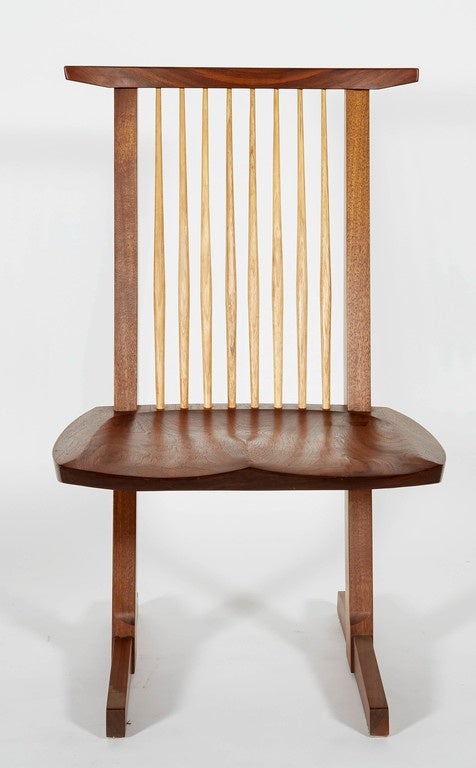 A wonderful Conoid dining chair originally designed by George Nakashima.  The seat has a a classic Nakashima rosewood butterfly. These chairs are signed and dated by Mira Nakashima.