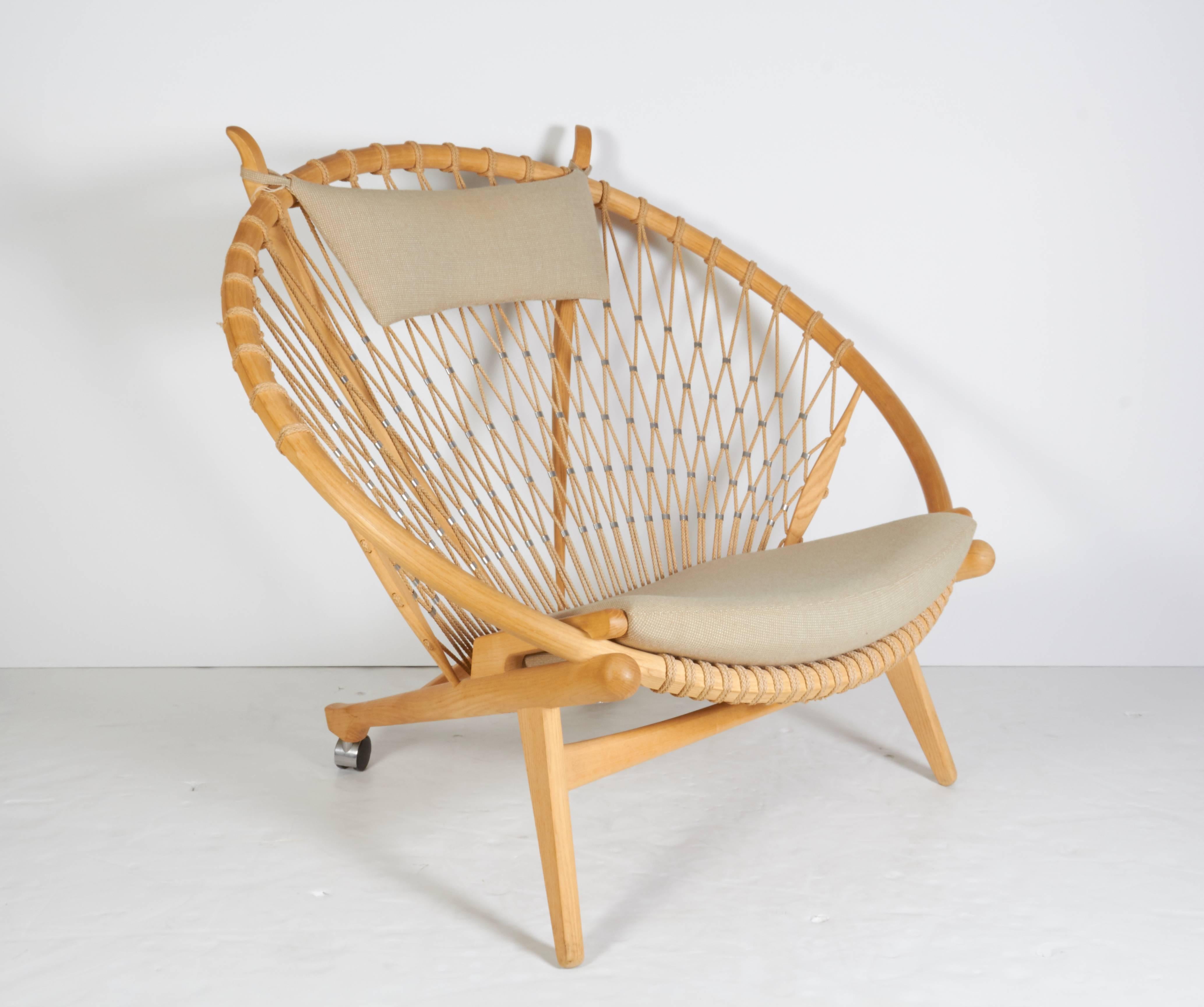 A radical Wegner design this lounge chair's seat and back are mounted with flag halyard and a loose seat cushion upholstered in wool with back legs on casters. Designed in 1985. Produced by PP Møbler.