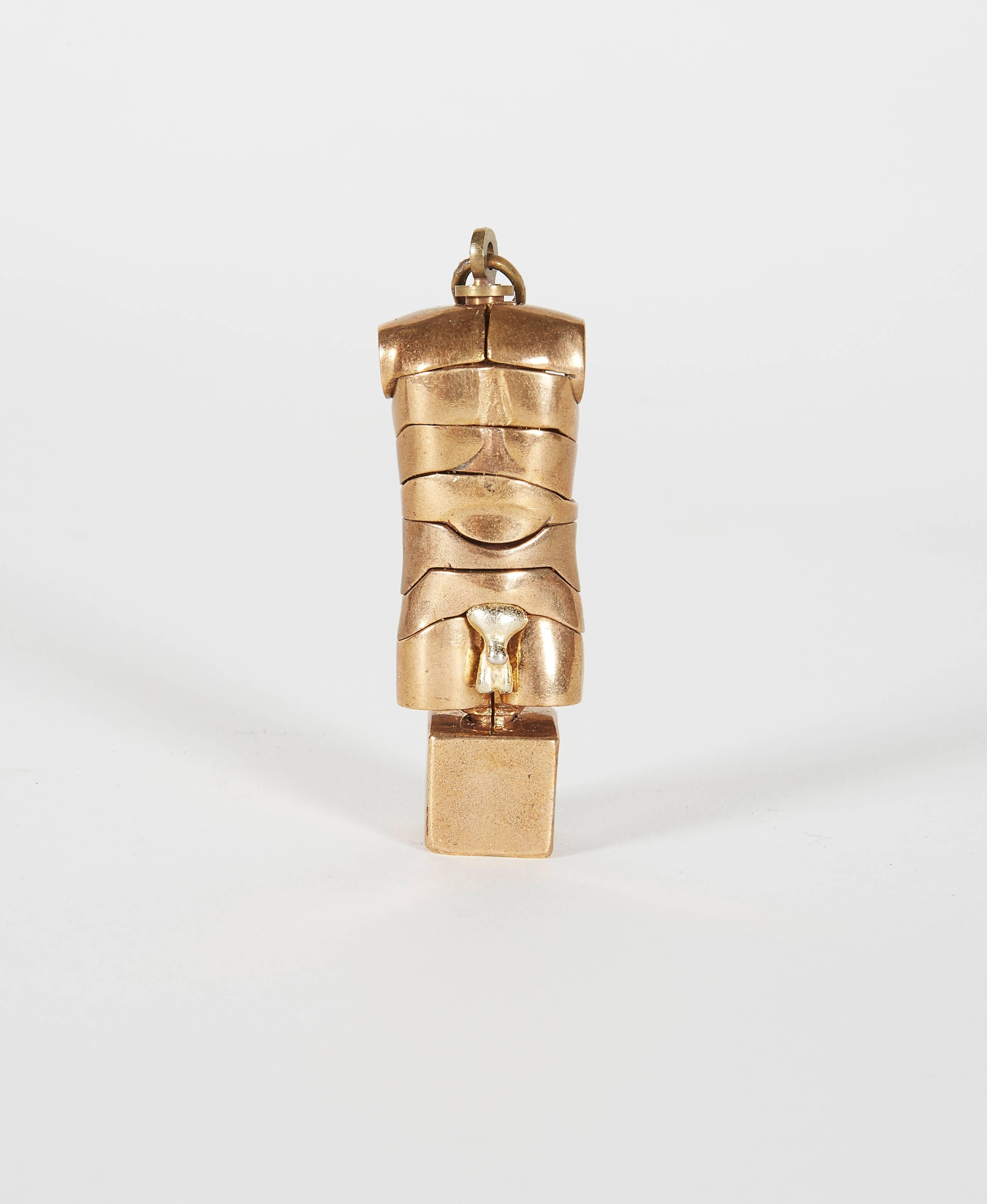 A bronze micro David erotic puzzle sculpture pendant modeled as a man's torso. It comes untouched in it's original box with guarantee certificate and a rare display stand. The measurements include the stand.