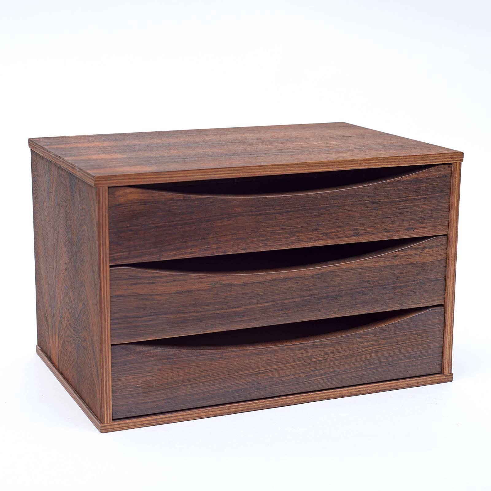 A practical and attractive small chest of drawers that could be used for a variety of purposes. Usually found in teak this is an outstanding rosewood version.