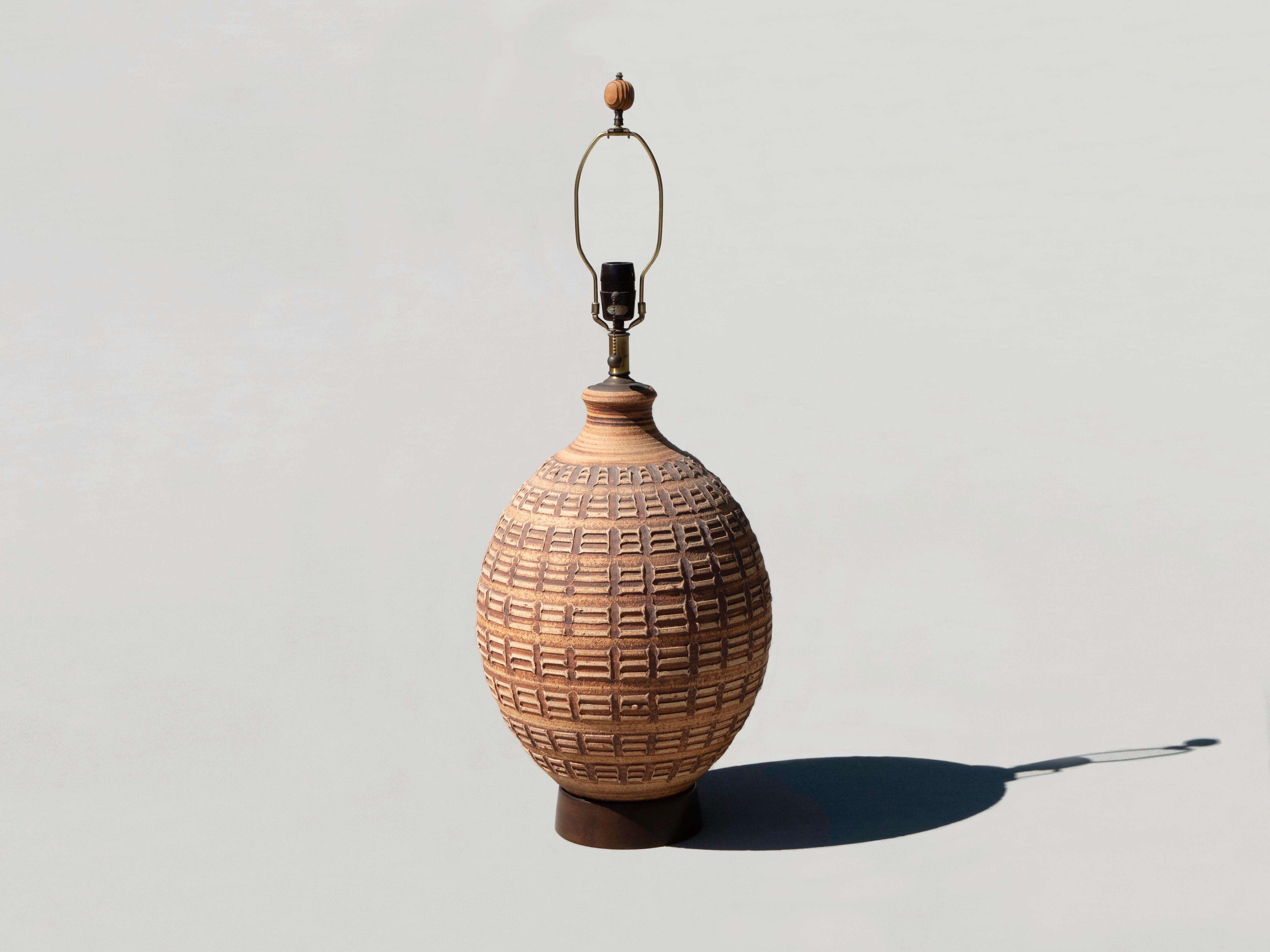 Stoneware table lamp by Bob Kinzie for his California based company, Affiliated Craftsmen, circa 1960's/1970's. It is in excellent original condition -- no cracks, chips, gouges, or scrapes. Beautiful stoneware pattern on a solid wood base. The plug