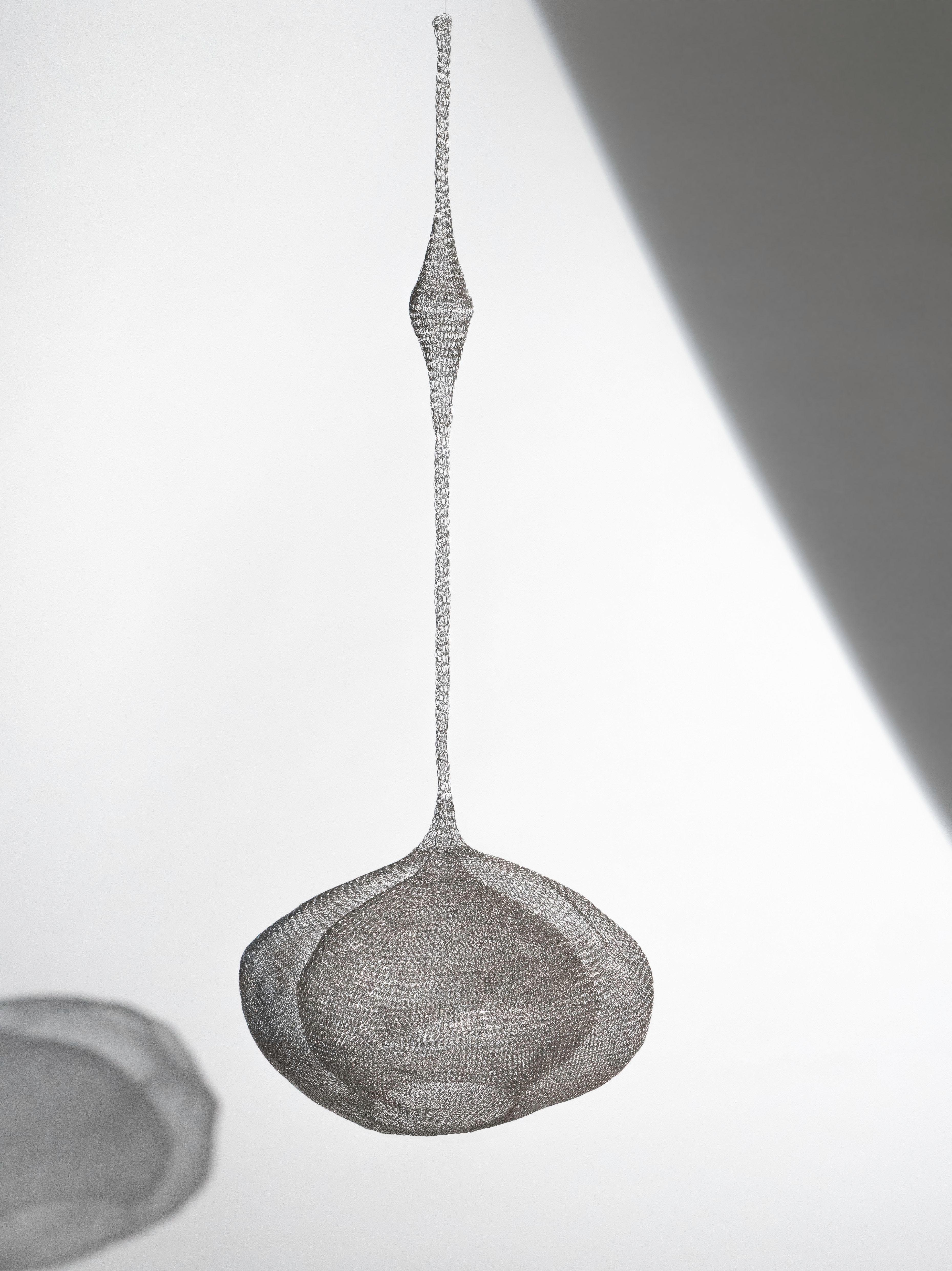 A hand-made mesh wire sculpture in the style of designer Ruth Asawa.  A continuous piece of wire, looped together to form an organic shape.  The abstract piece is displayed suspended.  It is lightweight and in excellent condition.  No missing links