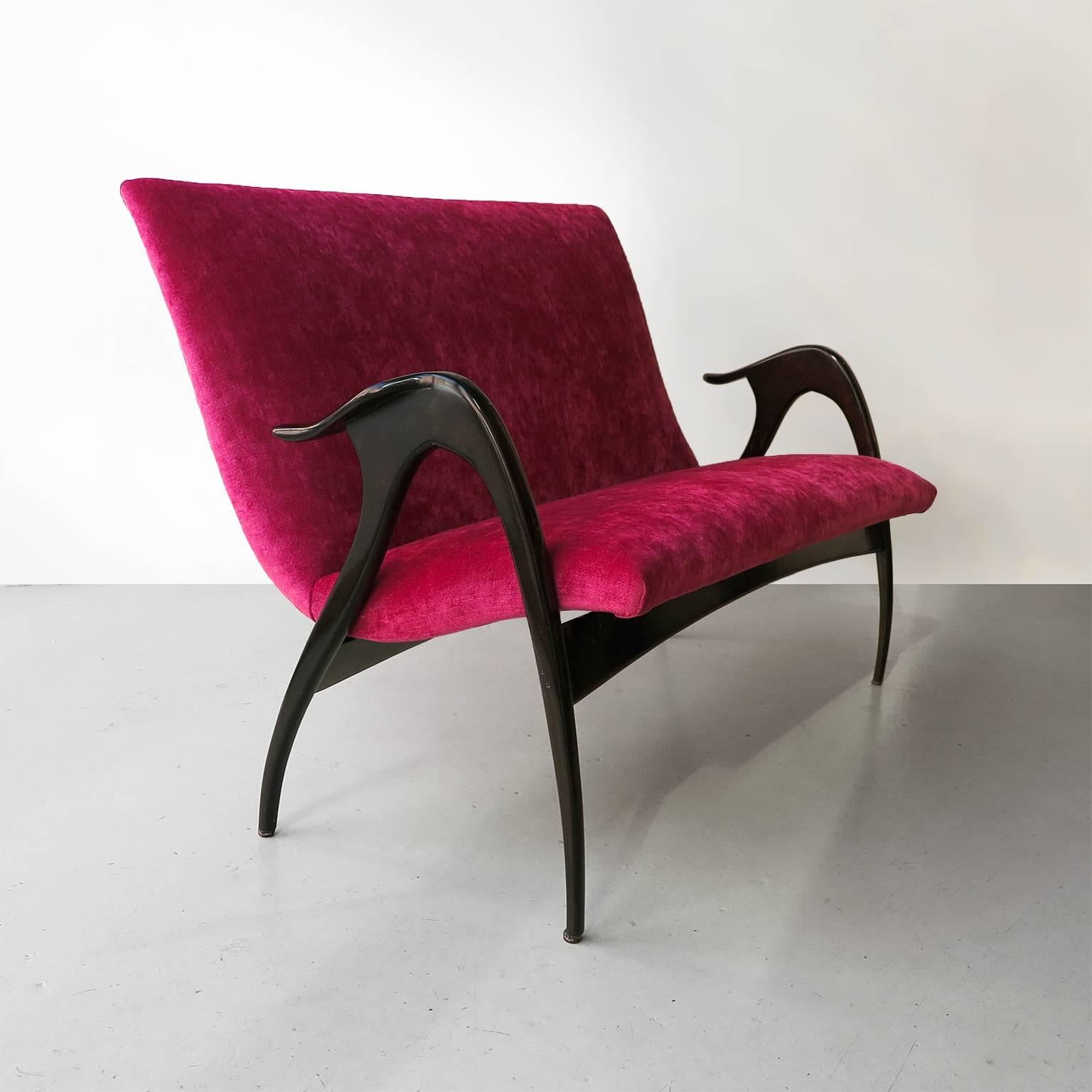 Sculptural mid-century settee in ebonized walnut with raspberry velvet upholstery by Malatesta & Mason, Roma, Italy, circa 1950.