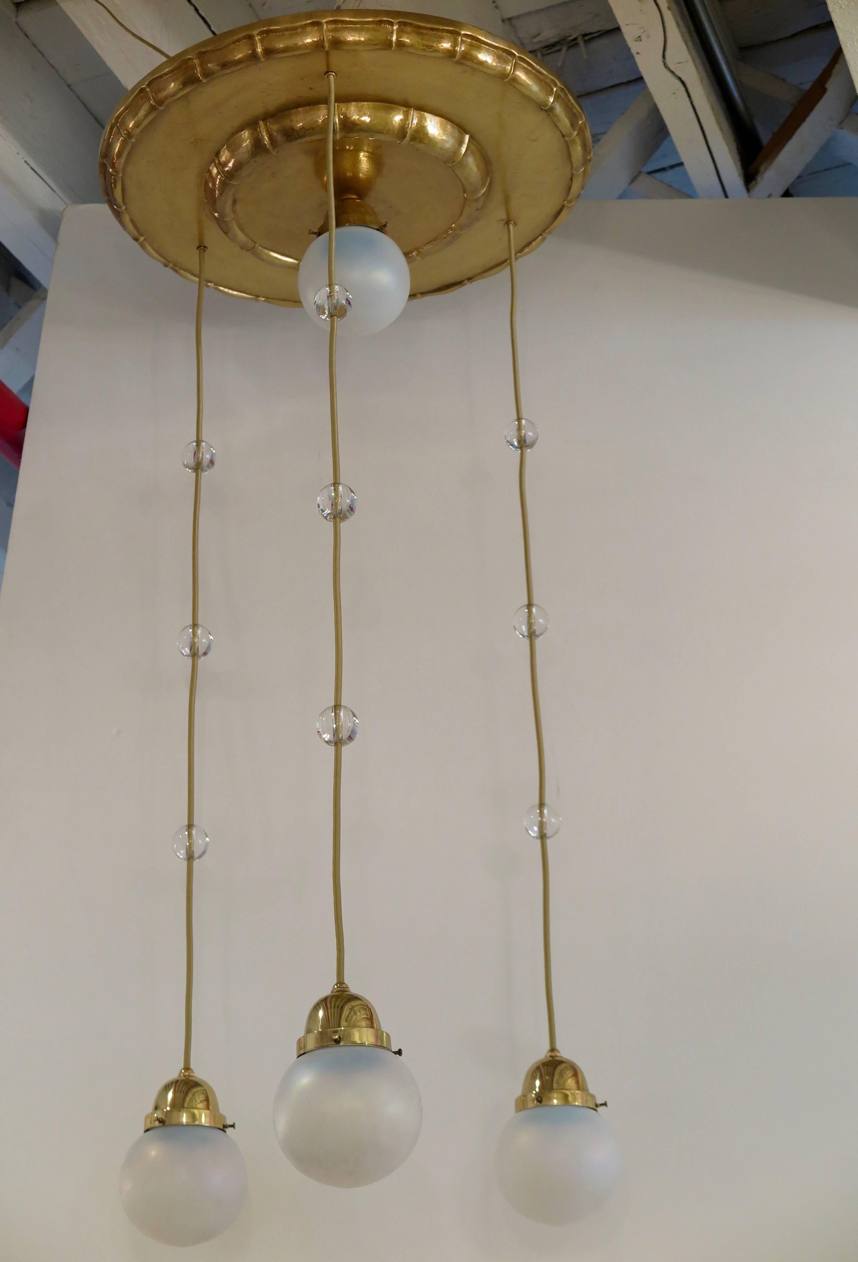 Vienna Secession chandelier with four handblown opalescent glass shades hanging from a decorative round dish in hammered bronze, attributed to Koloman Moser, Vienna, Austria, circa 1905.
Height is adjustable.
Newly electrified for USA.