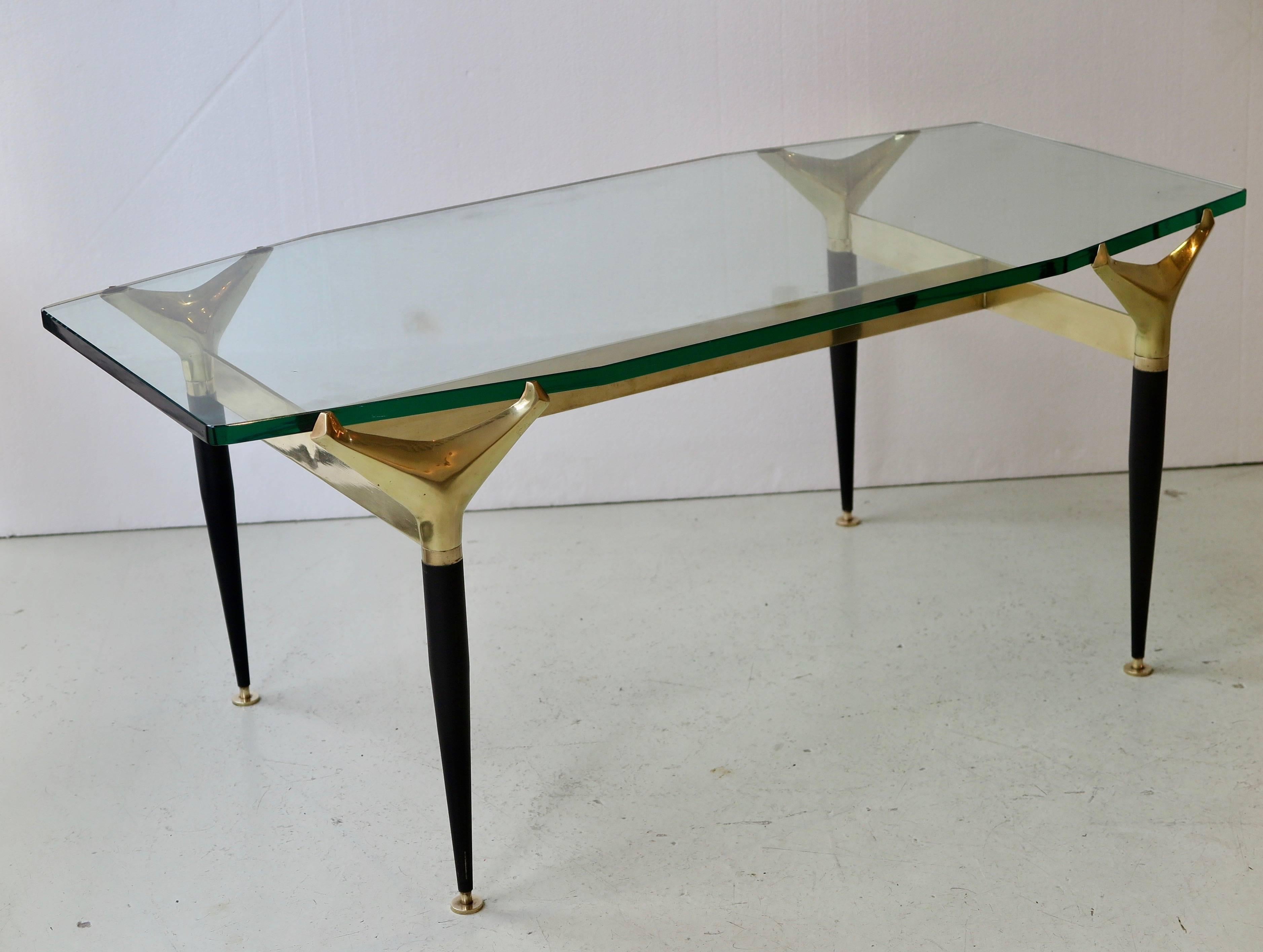Fontana Arte (attributed) Mid-Century Modern coffee table with elegant polished and patinated brass structure holding a clear glass top tapered on both ends.