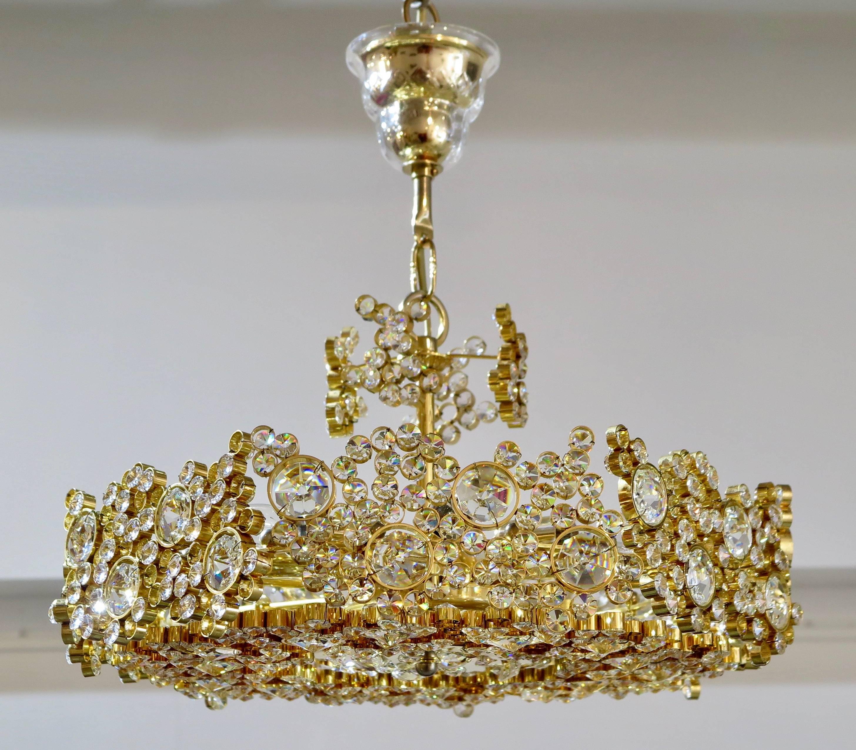 Spectacular jewel like chandelier with hundreds of crystals set in gold plated brass in the style of Lobmeyr, Austria, circa 1960. Newly electrified with seven candelabra sockets.