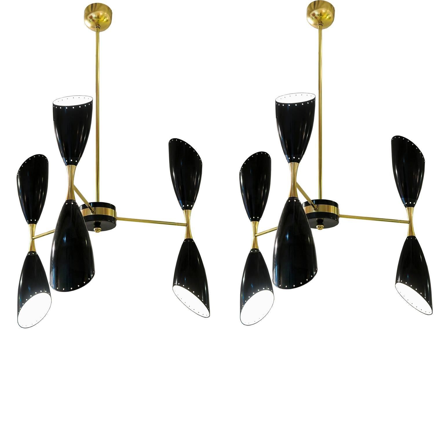 Pair Italian mid century modern  three-arm and six-light chandeliers in black lacquered perforated metal shades with elegant brass details, Italy, circa 1960.