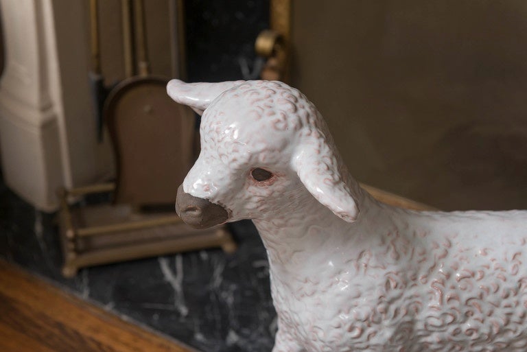 An adorable fine glazed pottery white baby lamb glazed overall in pale, pale pink to outline the curly coat. Matte finish around eyes, snout and inner ears.